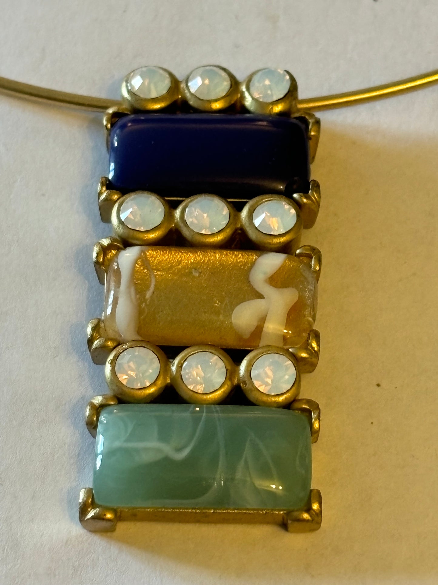 Solid gold metal necklace with blue and green sliding pendant