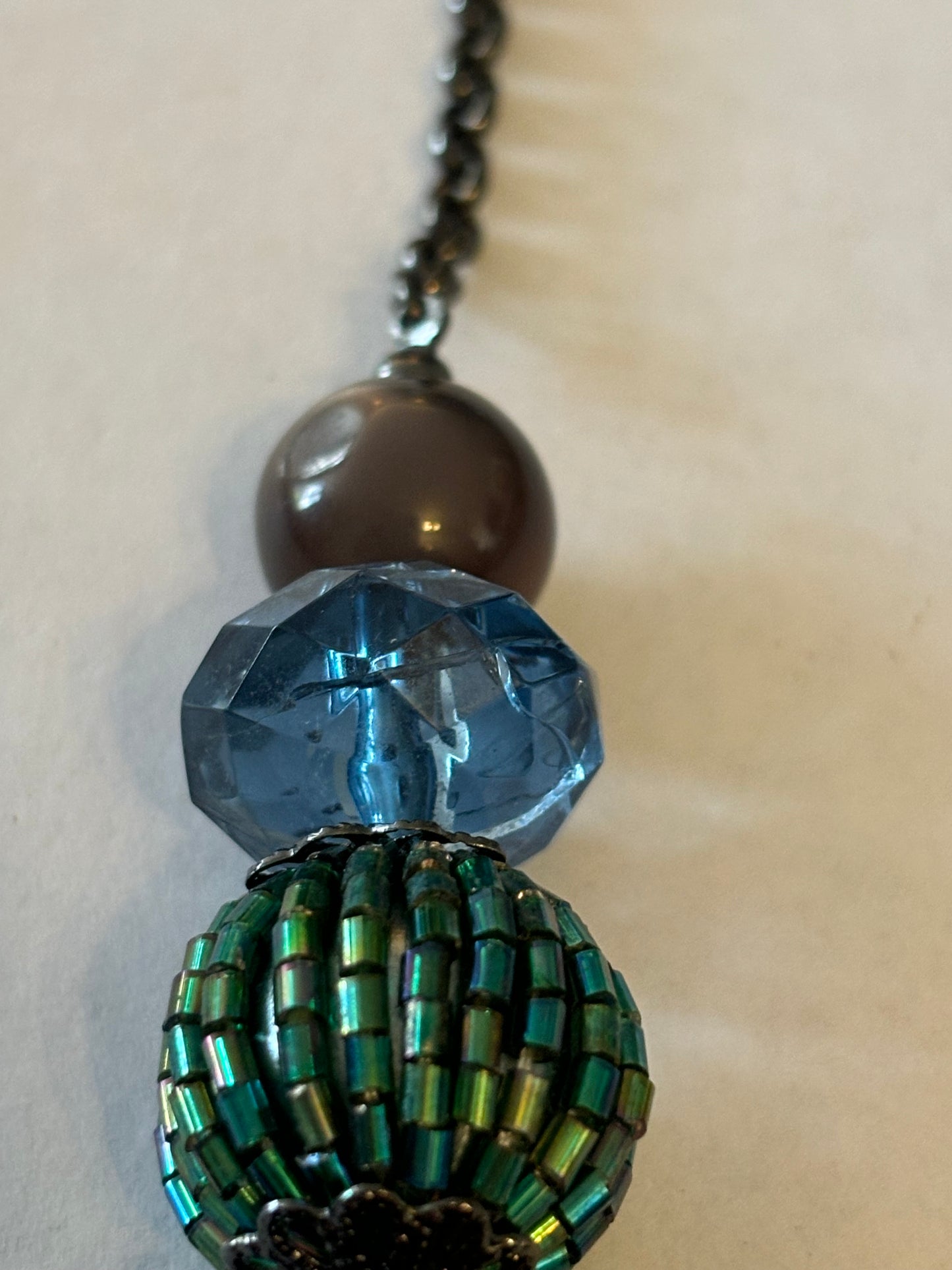 Dark metal necklace with varied dark blue green and purple beads