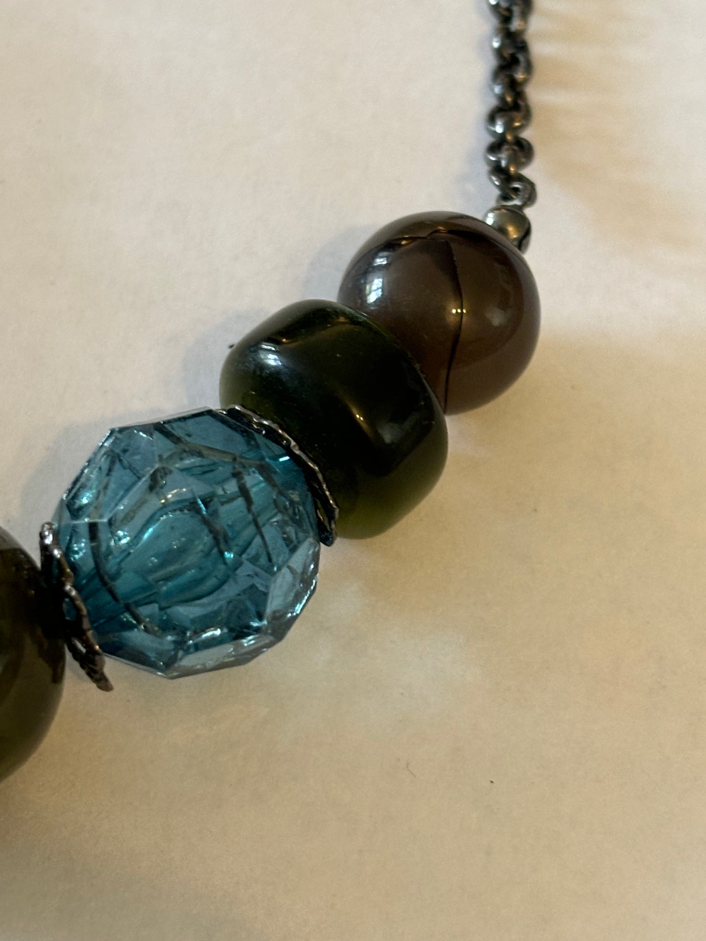 Dark metal necklace with varied dark blue green and purple beads