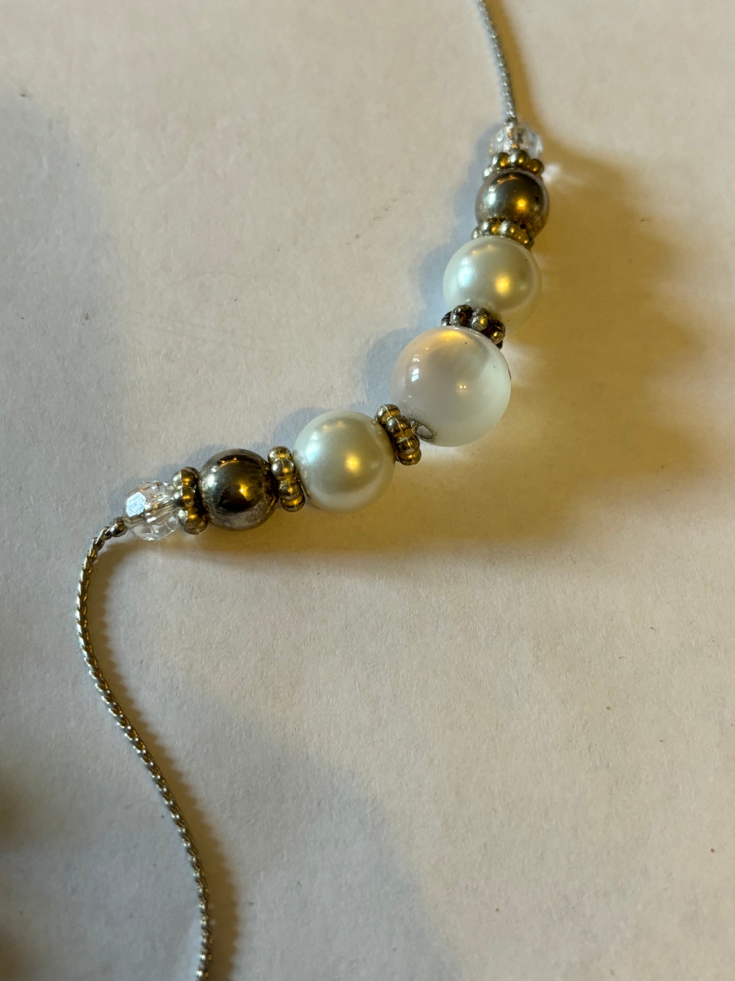 Long silver metal necklace with white, silver and pearlescent grouped beads