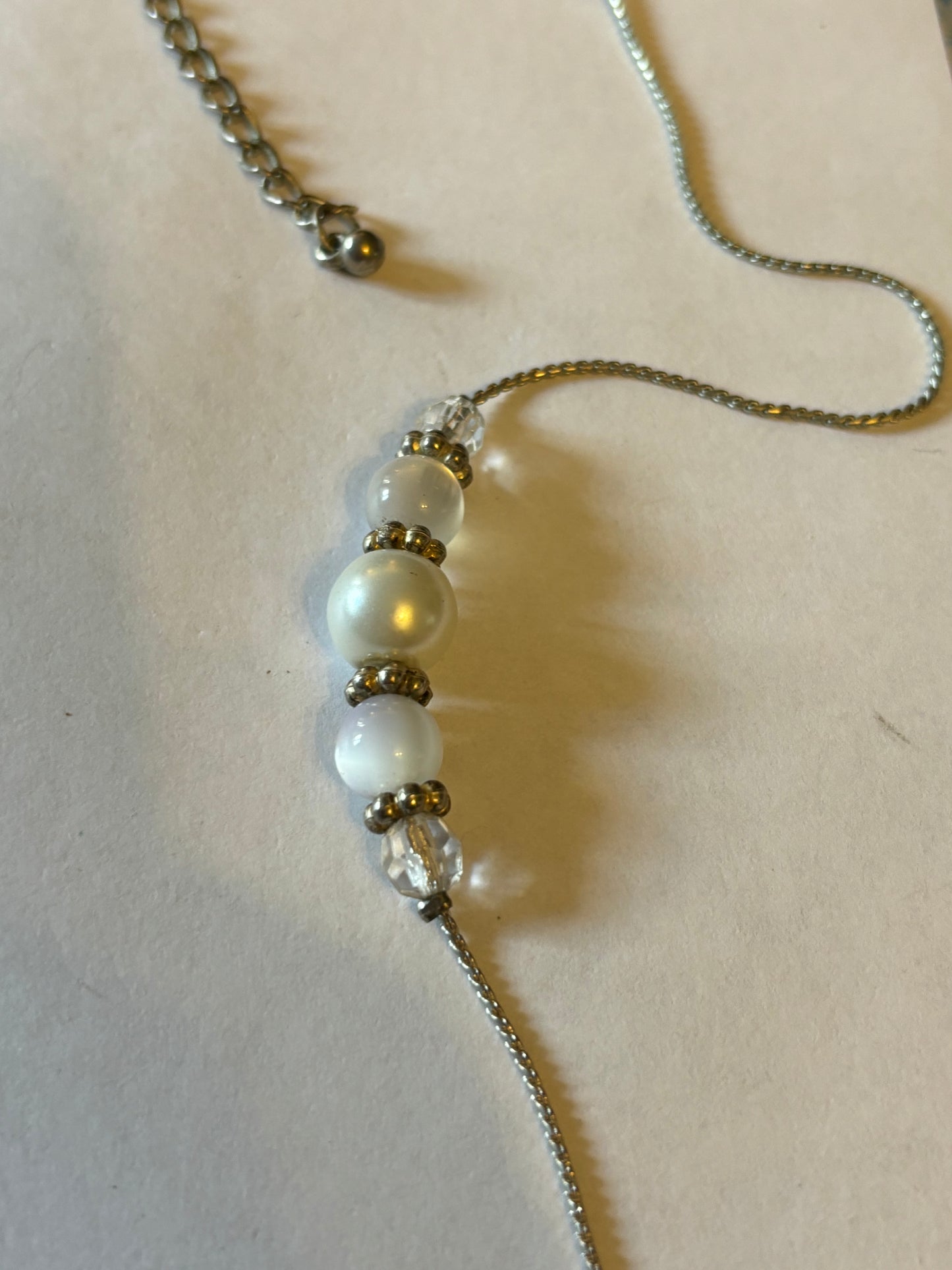 Long silver metal necklace with white, silver and pearlescent grouped beads