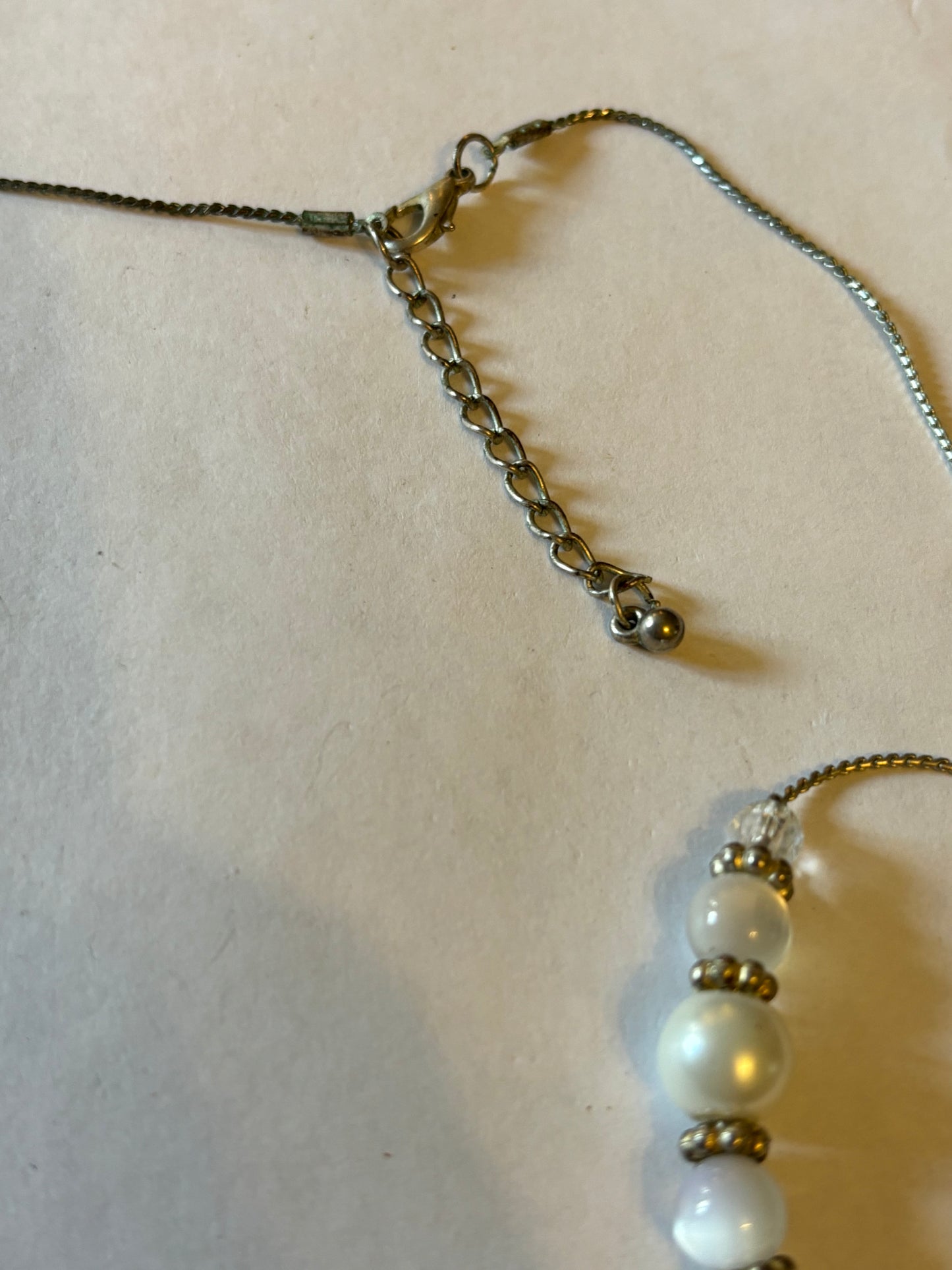 Long silver metal necklace with white, silver and pearlescent grouped beads