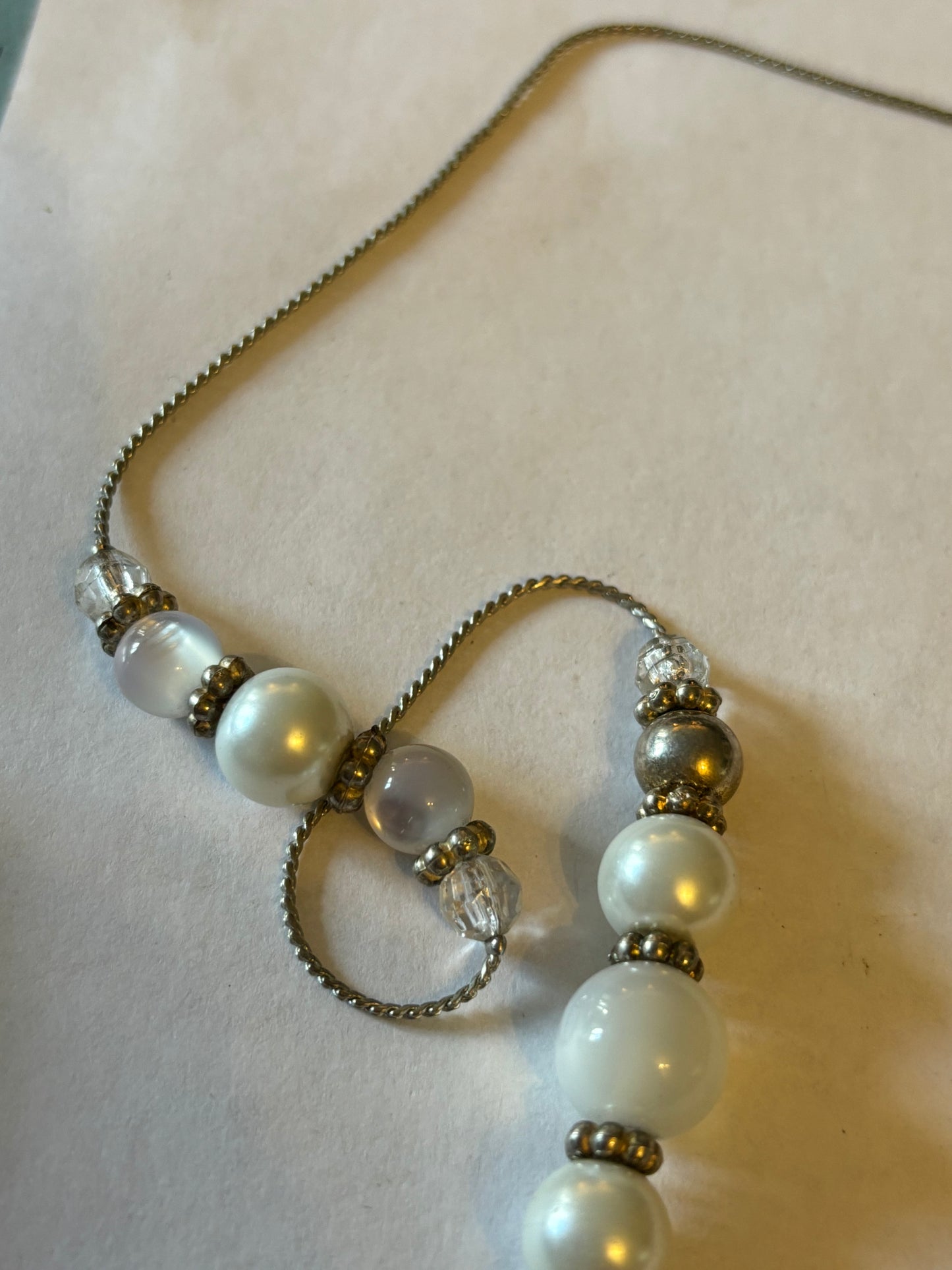 Long silver metal necklace with white, silver and pearlescent grouped beads