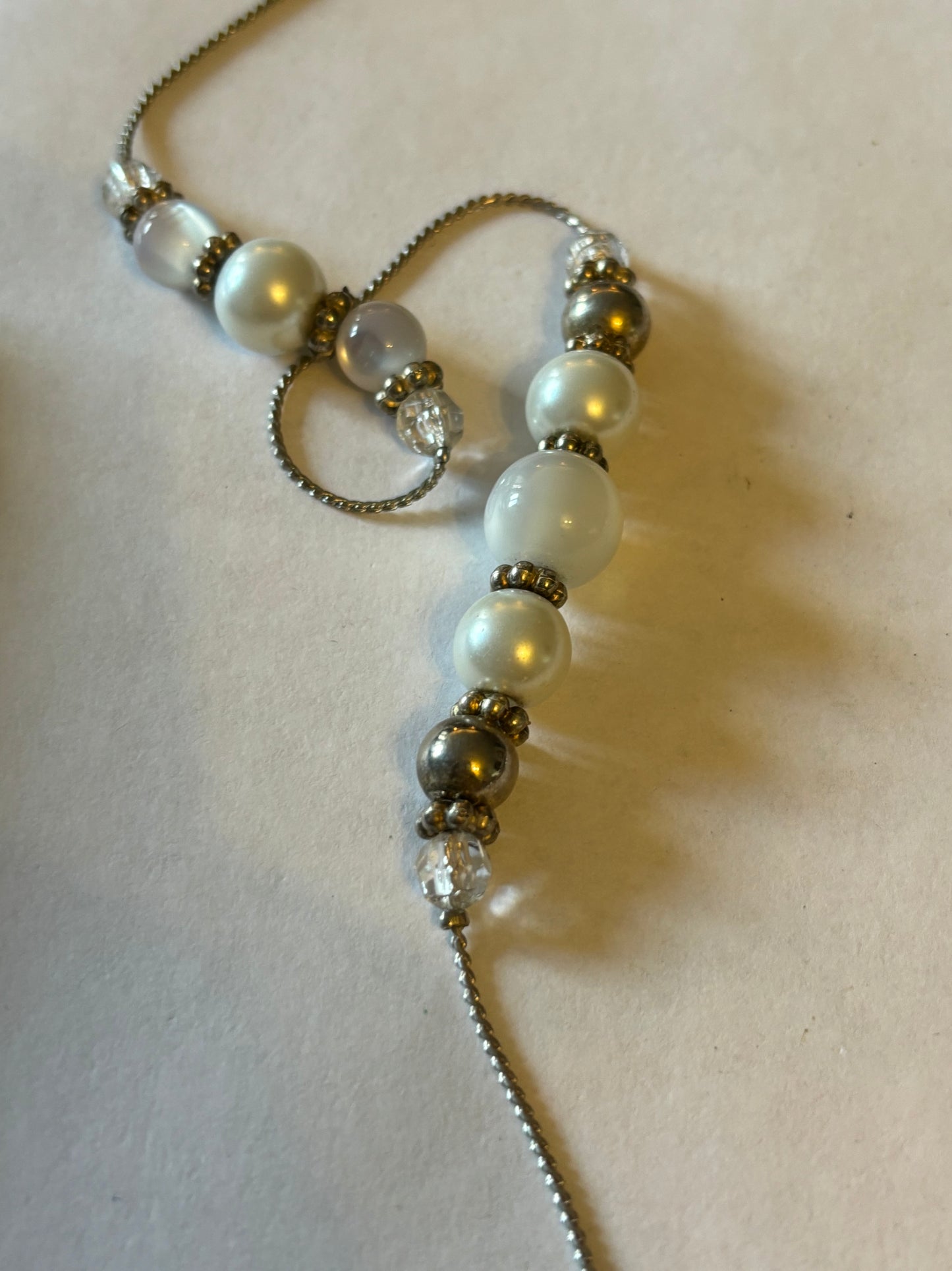 Long silver metal necklace with white, silver and pearlescent grouped beads