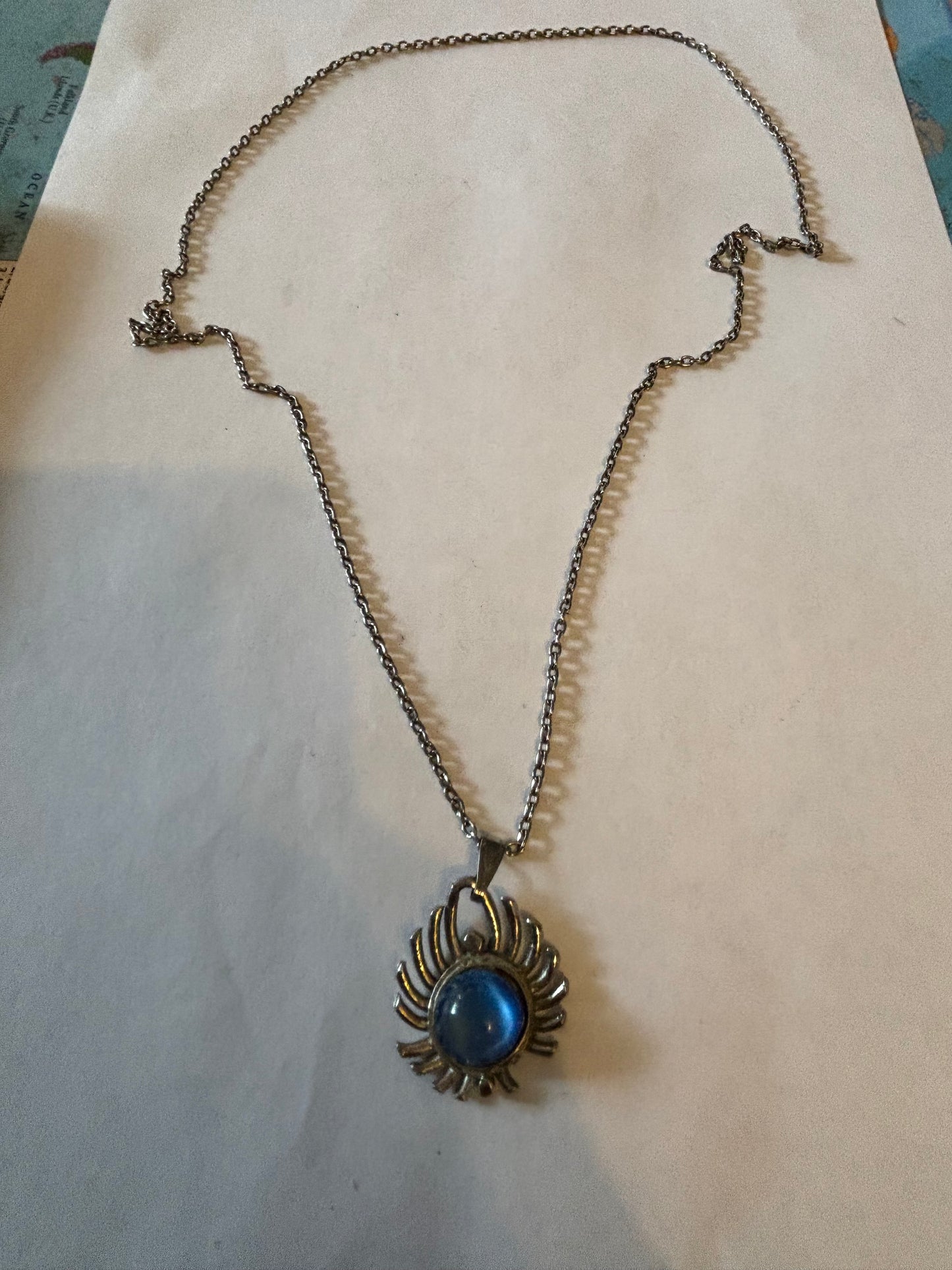 Long silver metal necklace with vivid blue stone pendant