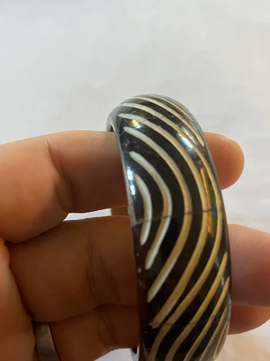 Metal bangle with black and white wavy pattern