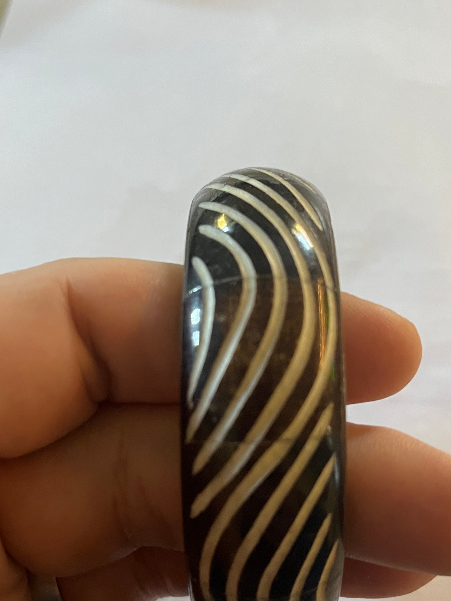 Metal bangle with black and white wavy pattern