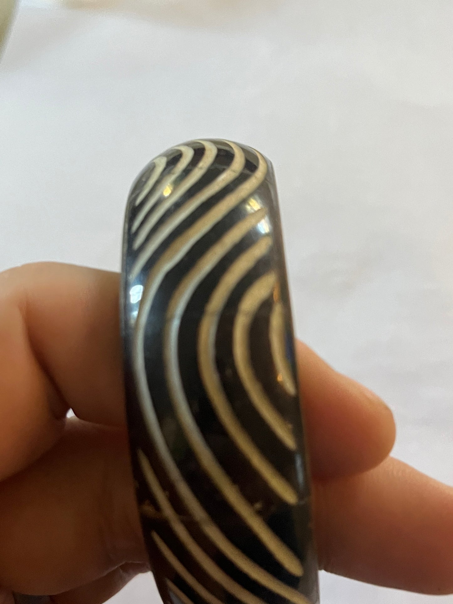 Metal bangle with black and white wavy pattern