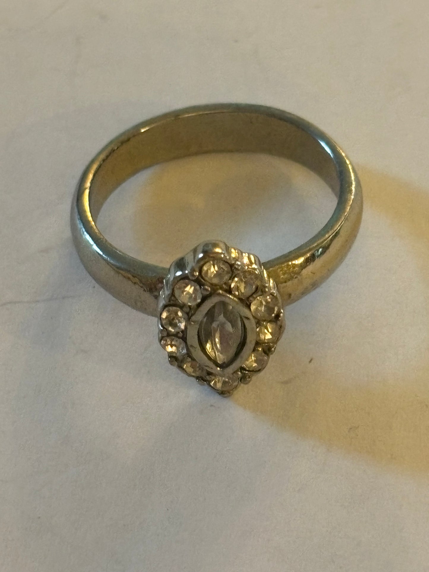 Silver ring with oval setting of small white stones surrounding larger centre