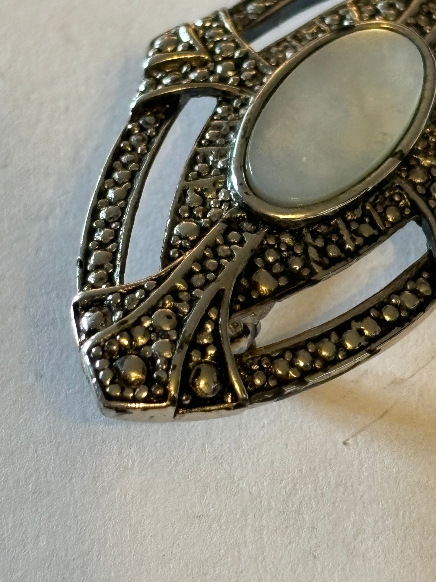 Oval silver Metal Textured Shield brooch with Pearlescent stone centre