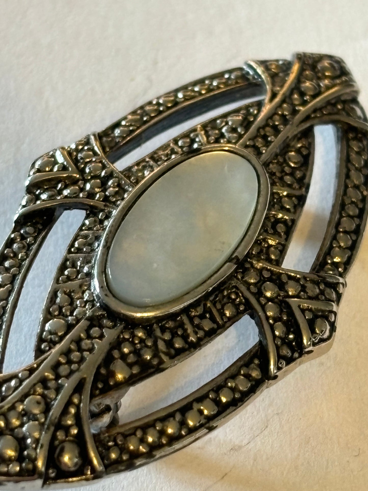 Oval silver Metal Textured Shield brooch with Pearlescent stone centre