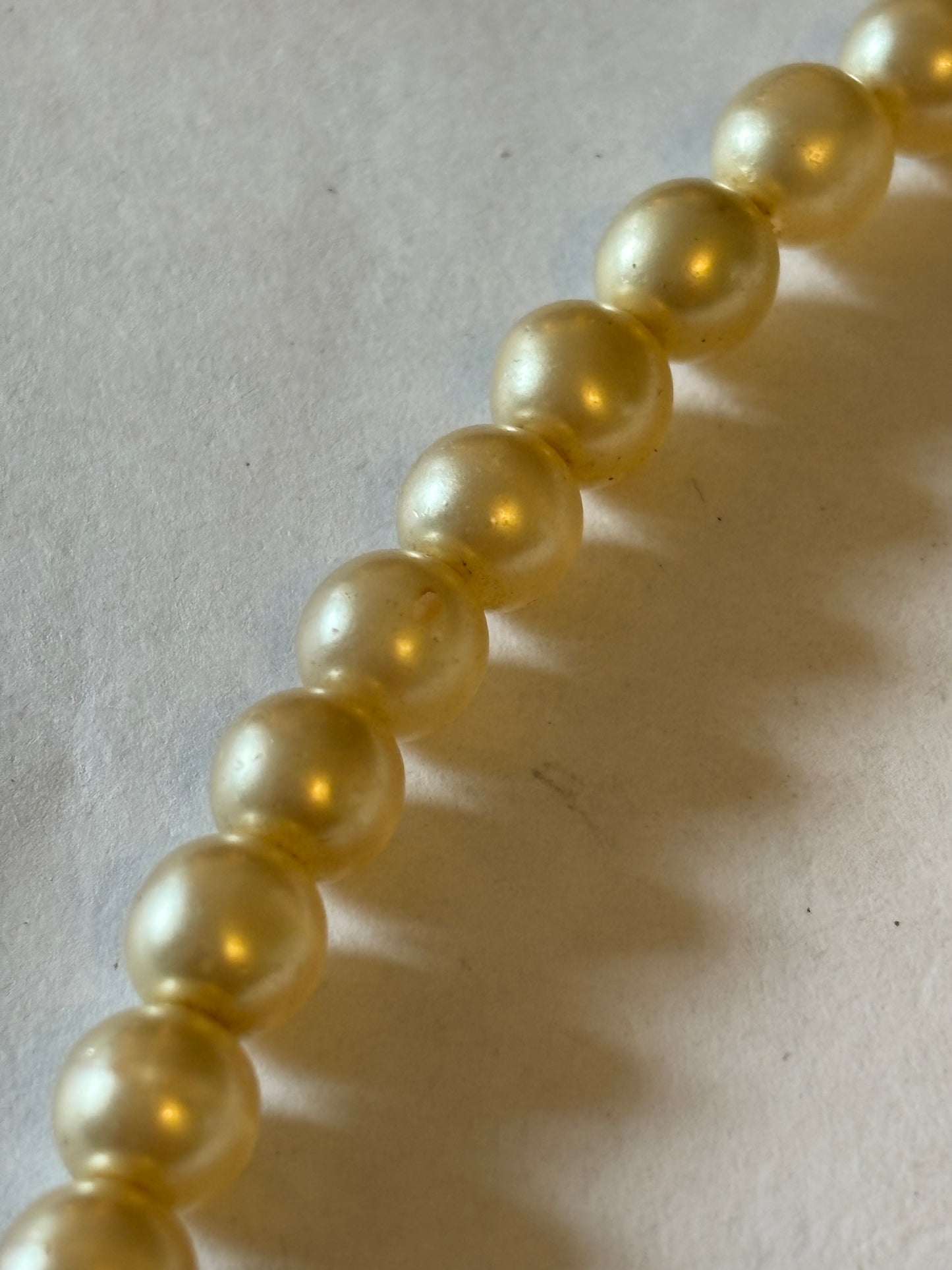 Pearlescent bead necklace with white discs and yellow centre