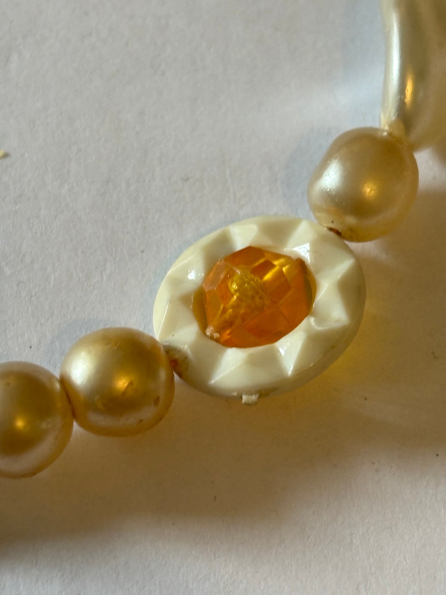 Pearlescent bead necklace with white discs and yellow centre