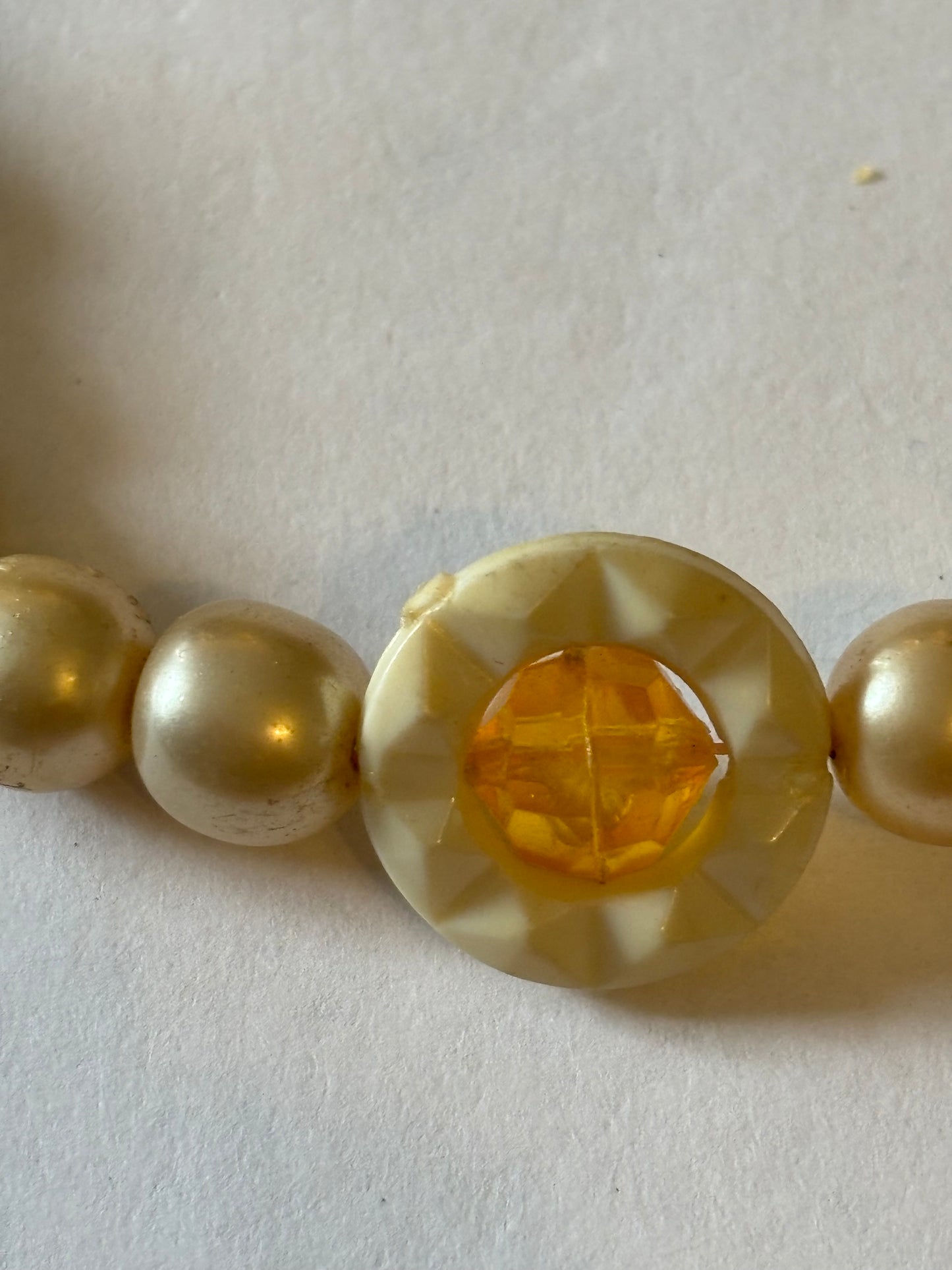 Pearlescent bead necklace with white discs and yellow centre