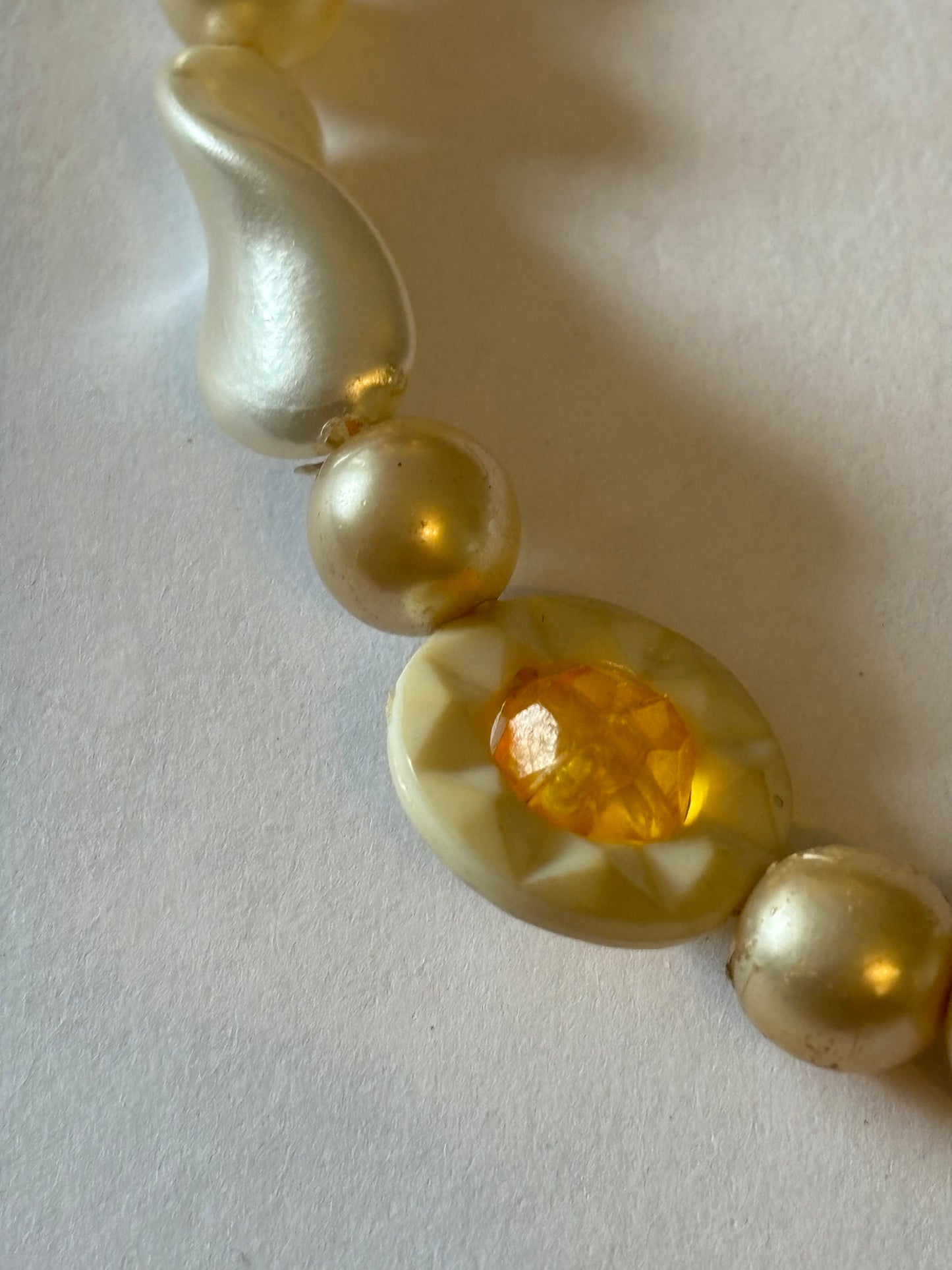 Pearlescent bead necklace with white discs and yellow centre