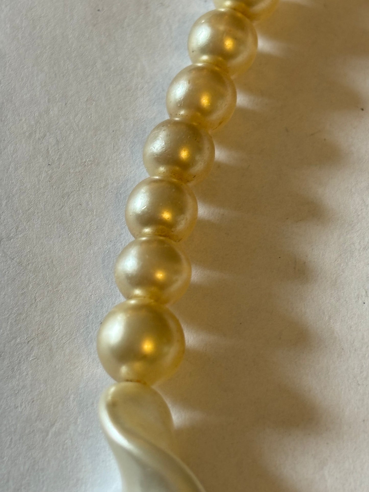 Pearlescent bead necklace with white discs and yellow centre