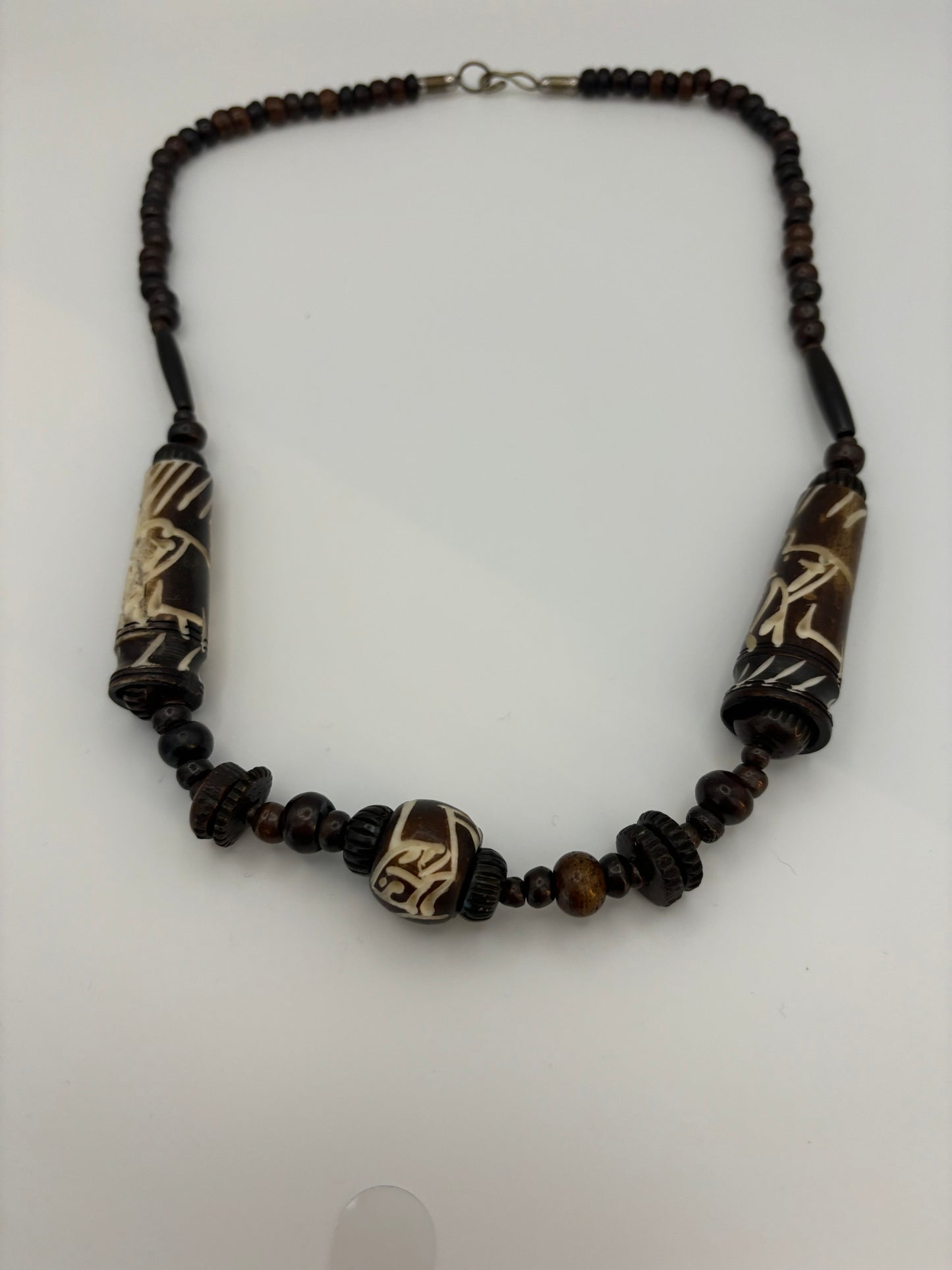 Dark brown beaded necklace with carved cylinders