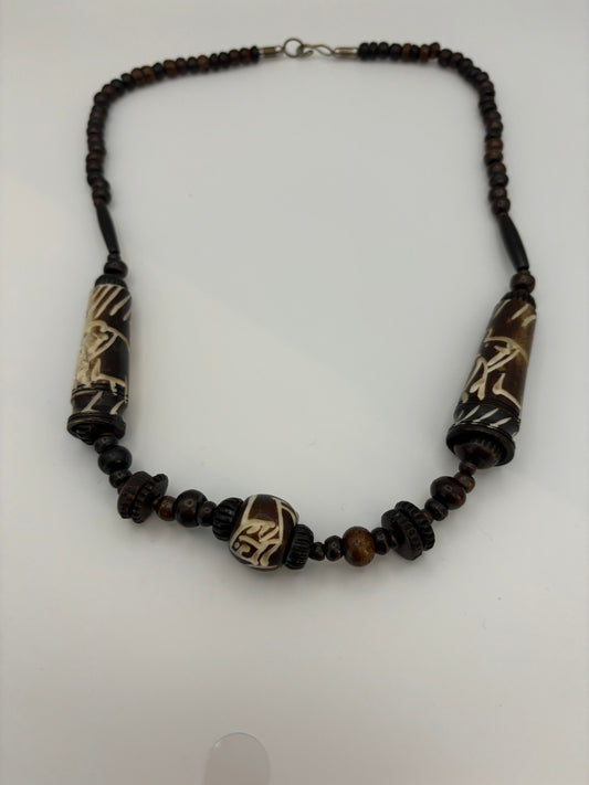 Dark brown beaded necklace with carved cylinders