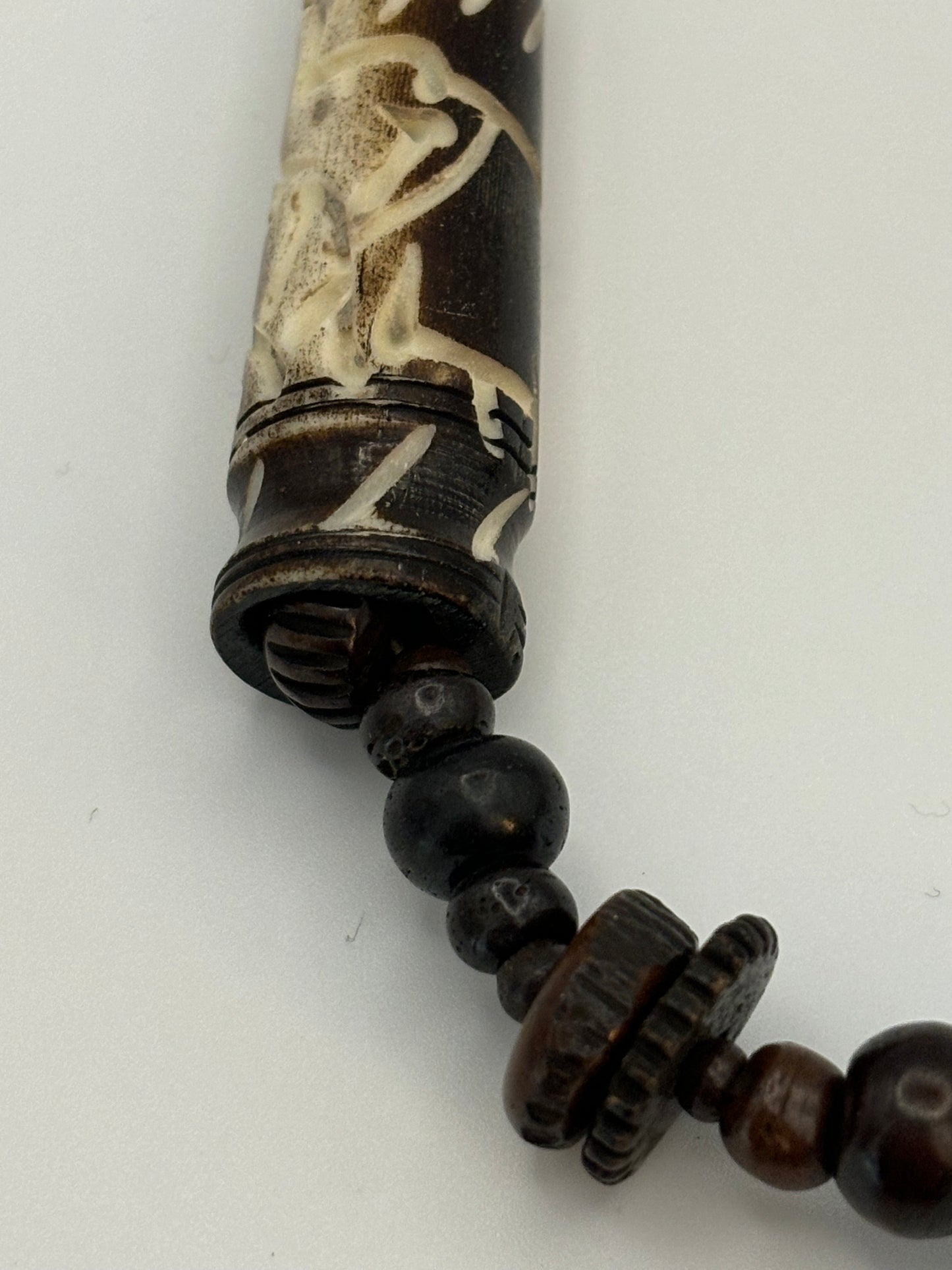 Dark brown beaded necklace with carved cylinders