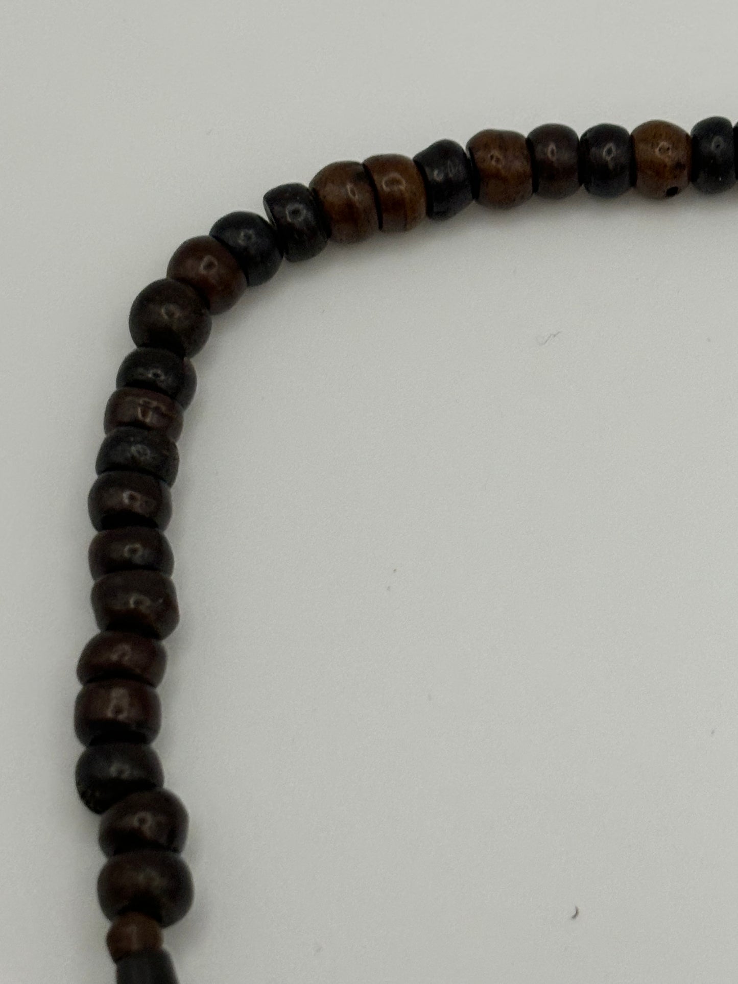 Dark brown beaded necklace with carved cylinders