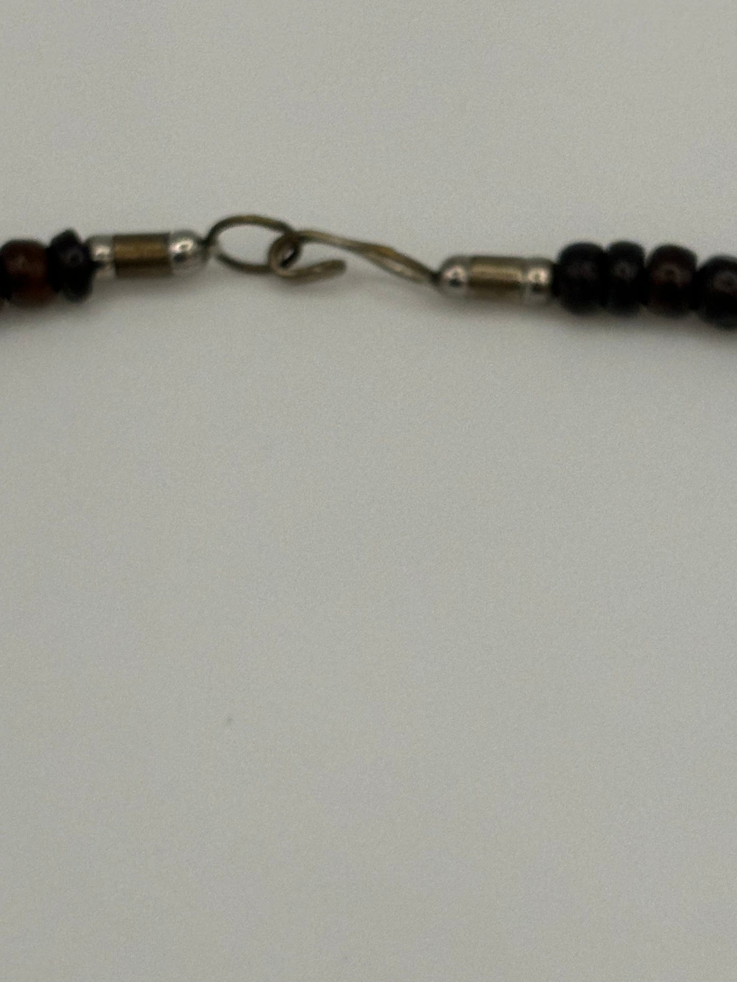 Dark brown beaded necklace with carved cylinders