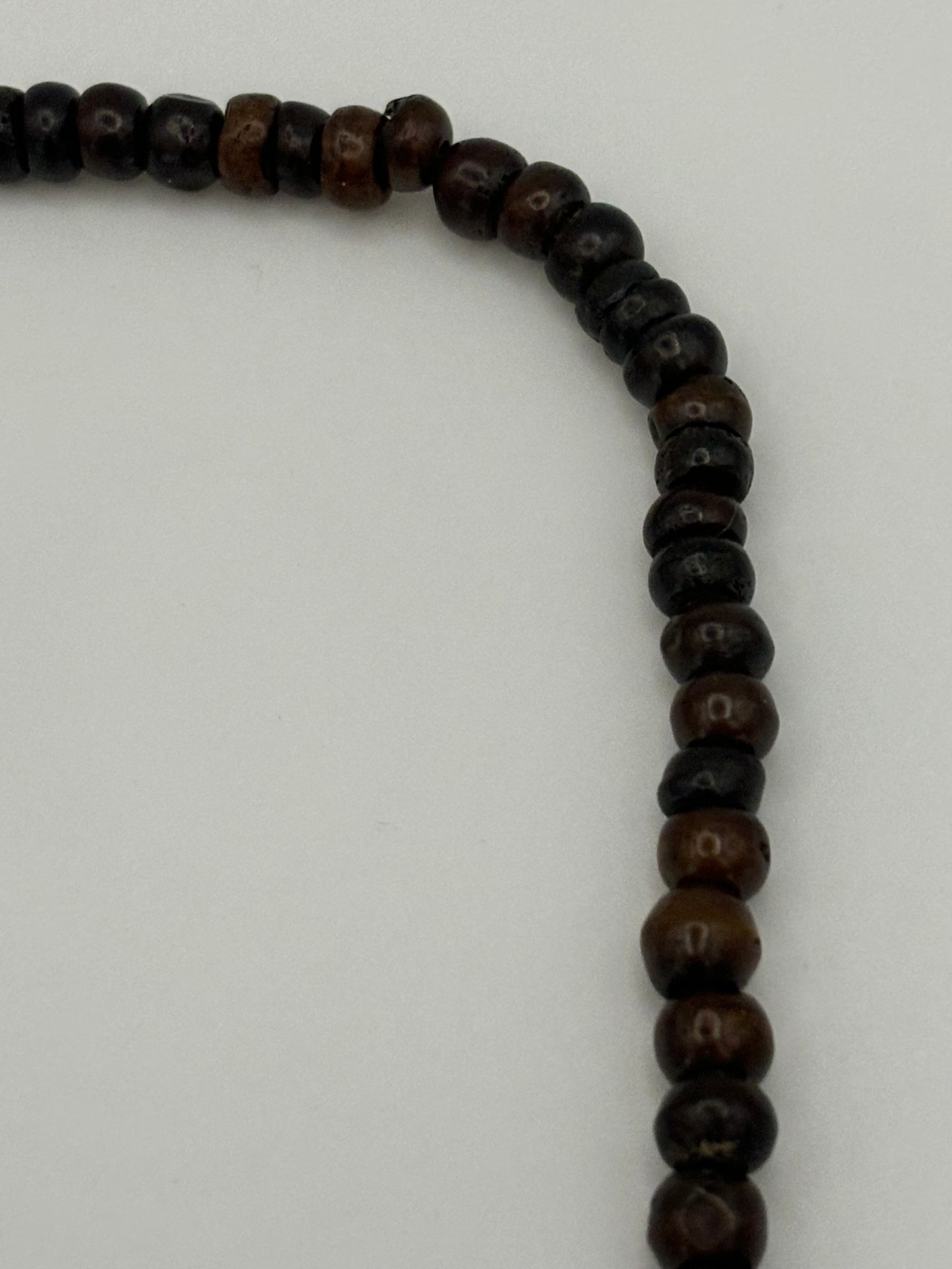 Dark brown beaded necklace with carved cylinders