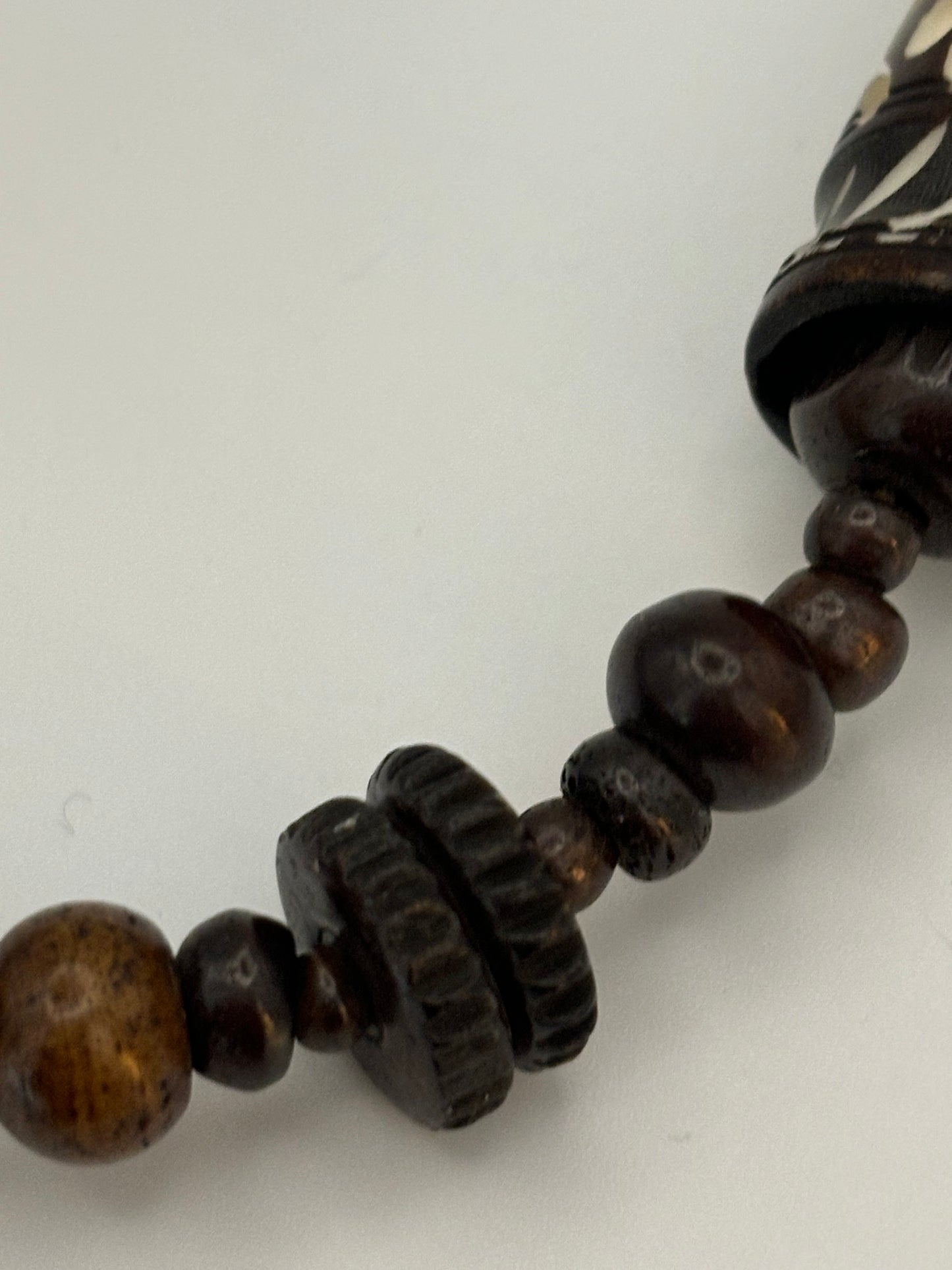 Dark brown beaded necklace with carved cylinders