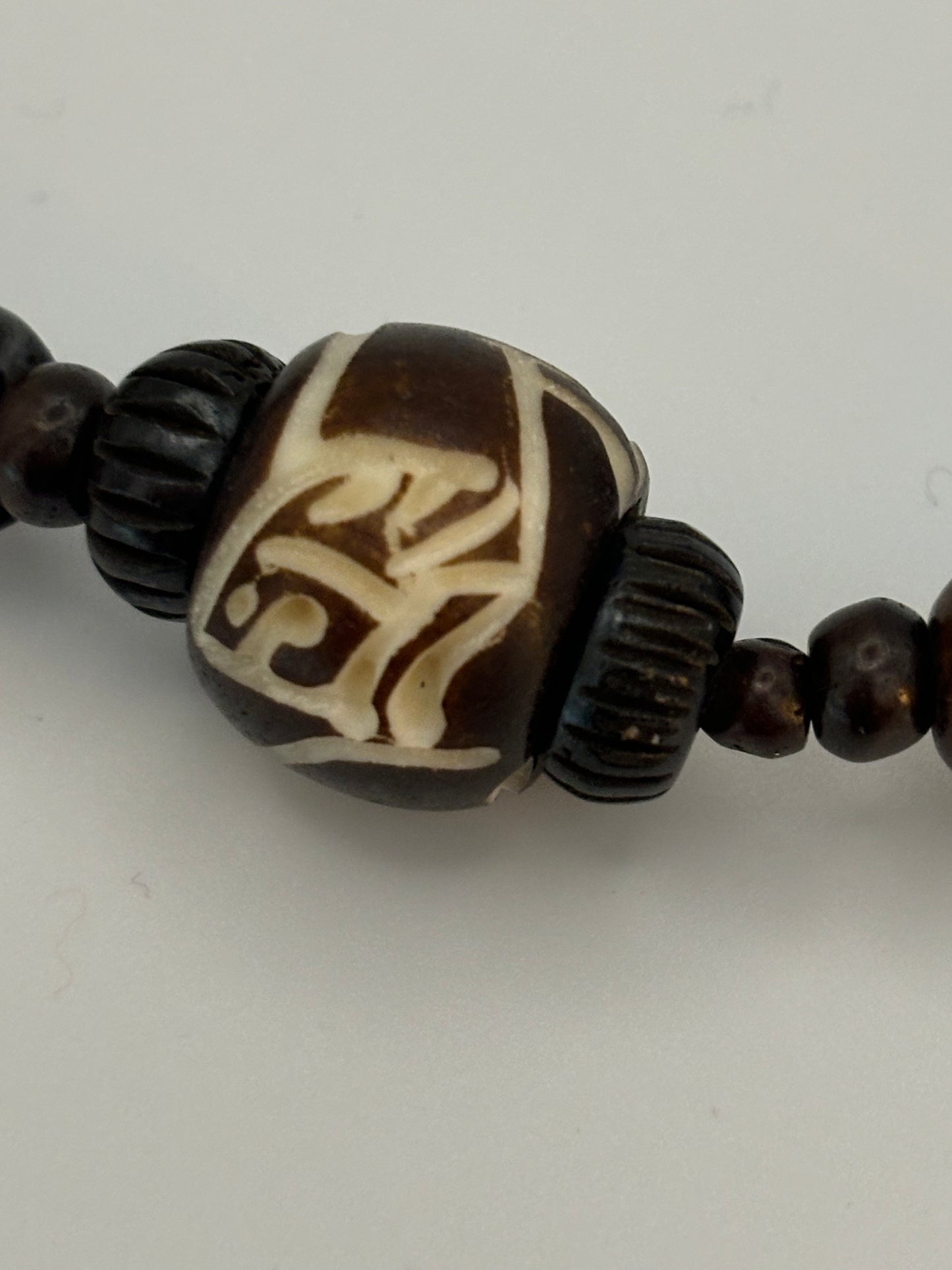 Dark brown beaded necklace with carved cylinders