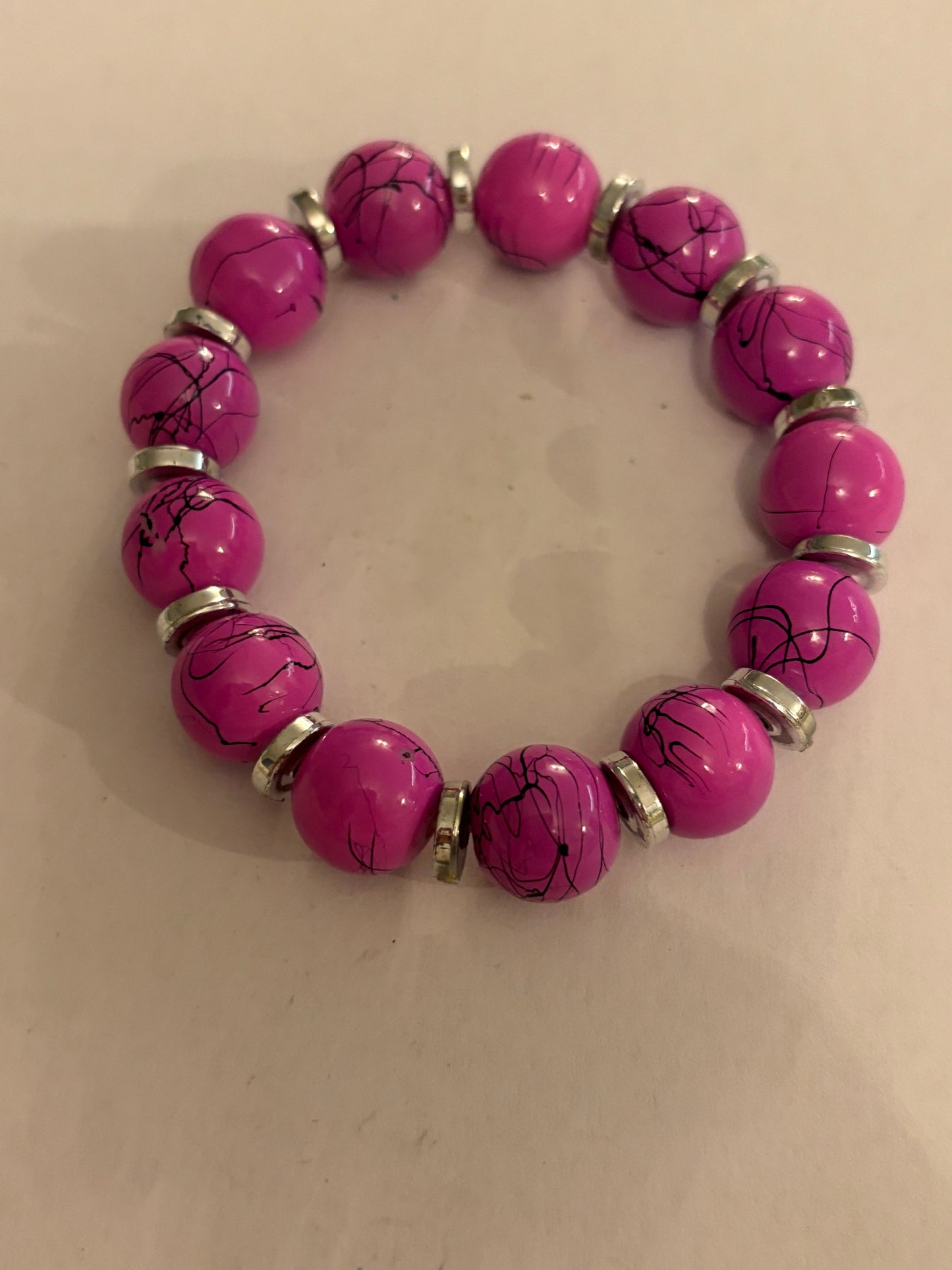 Pink cracked pattern bead stretch bracelet with silver disc spacers