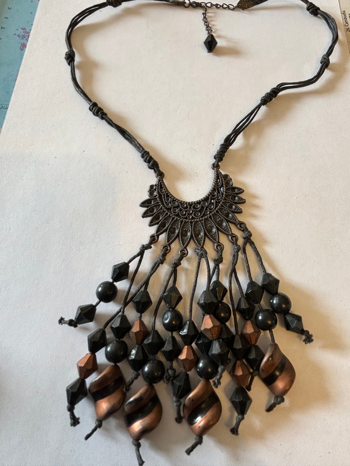 Dark leather necklace with dark metal pendant with black and bronze drop