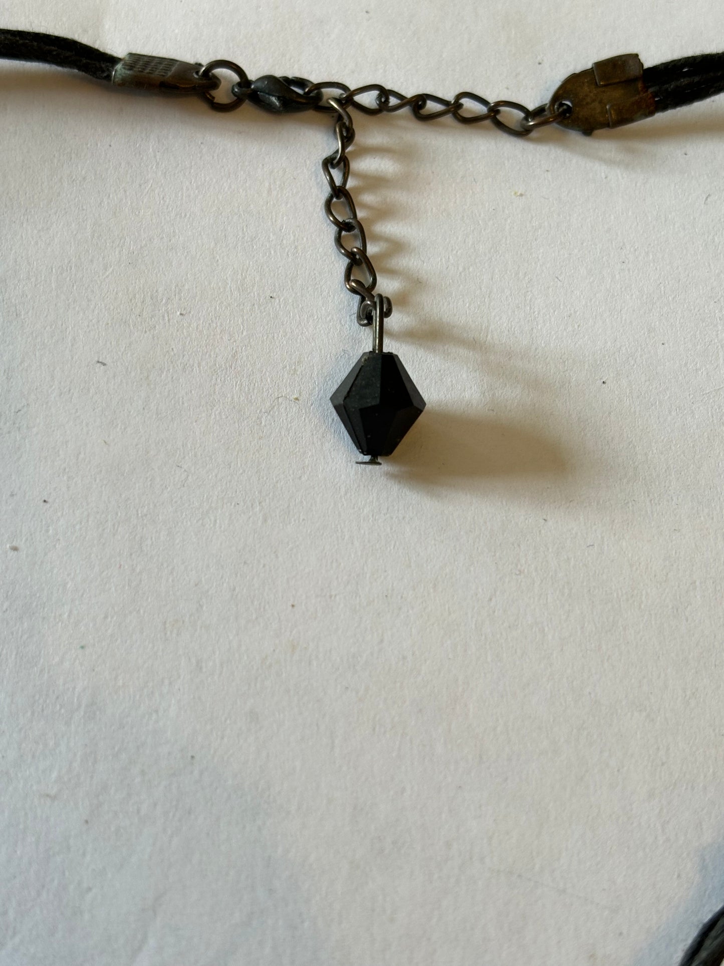 Dark leather necklace with dark metal pendant with black and bronze drop