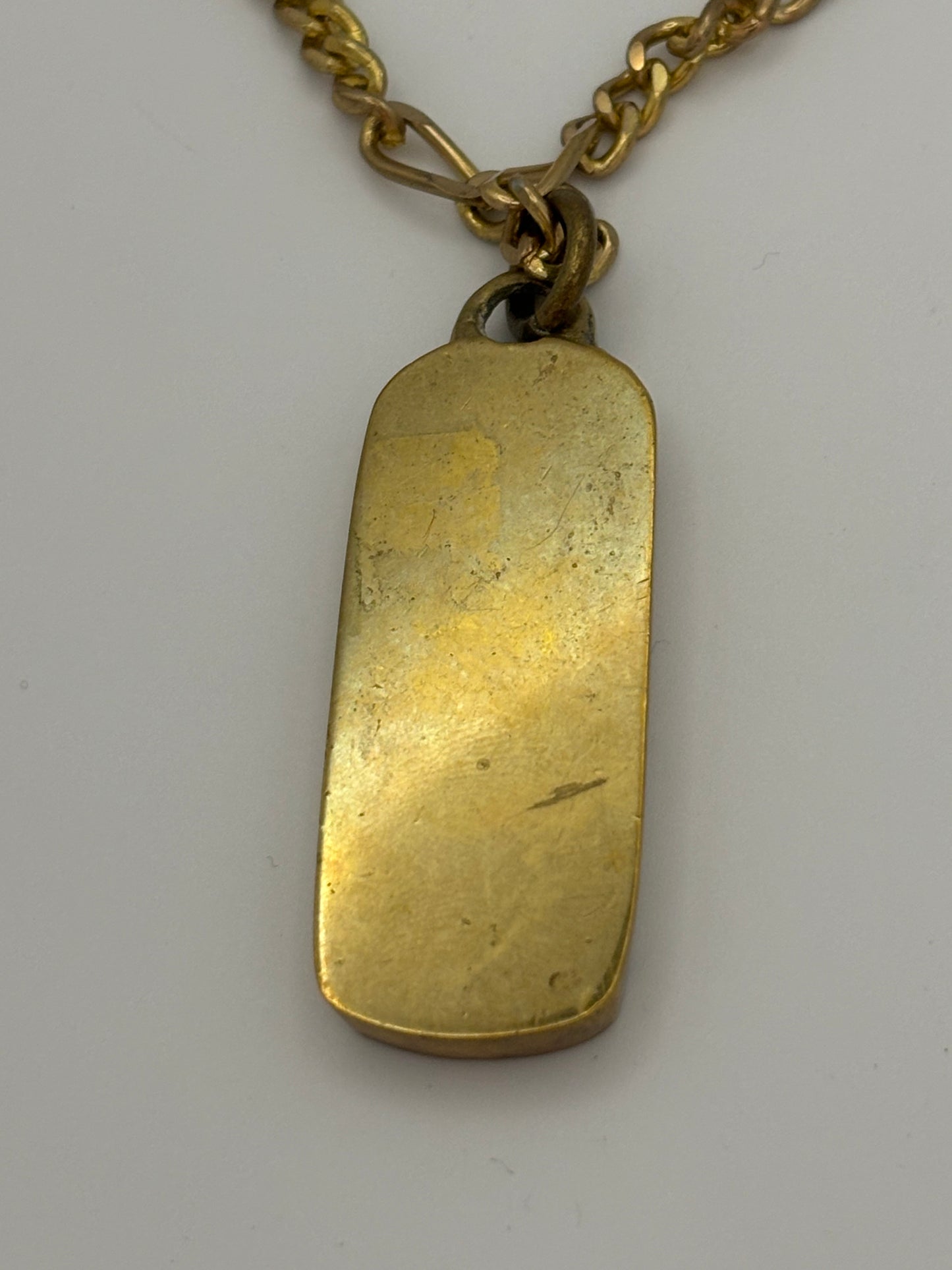 Gold metal necklace with ingot style Dolphin and coloured stone pendant