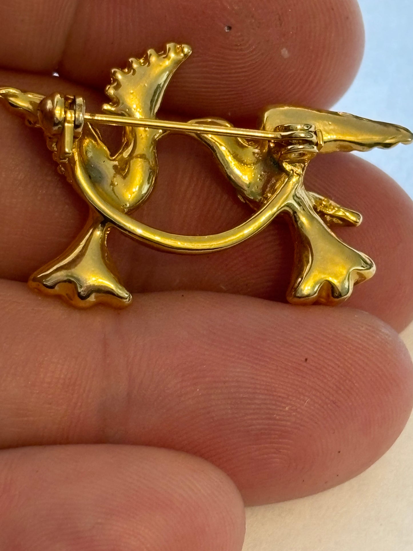 Bright gold metal brooch of two birds with diamantes