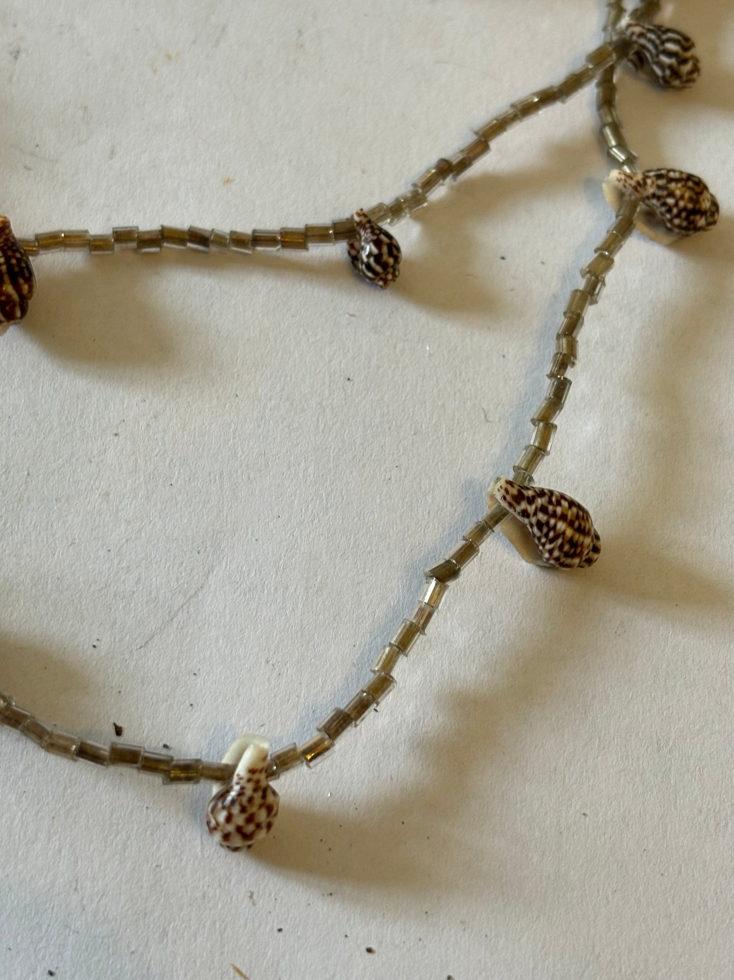 Small smokey triple tier bead necklace with very small seashells spaced along