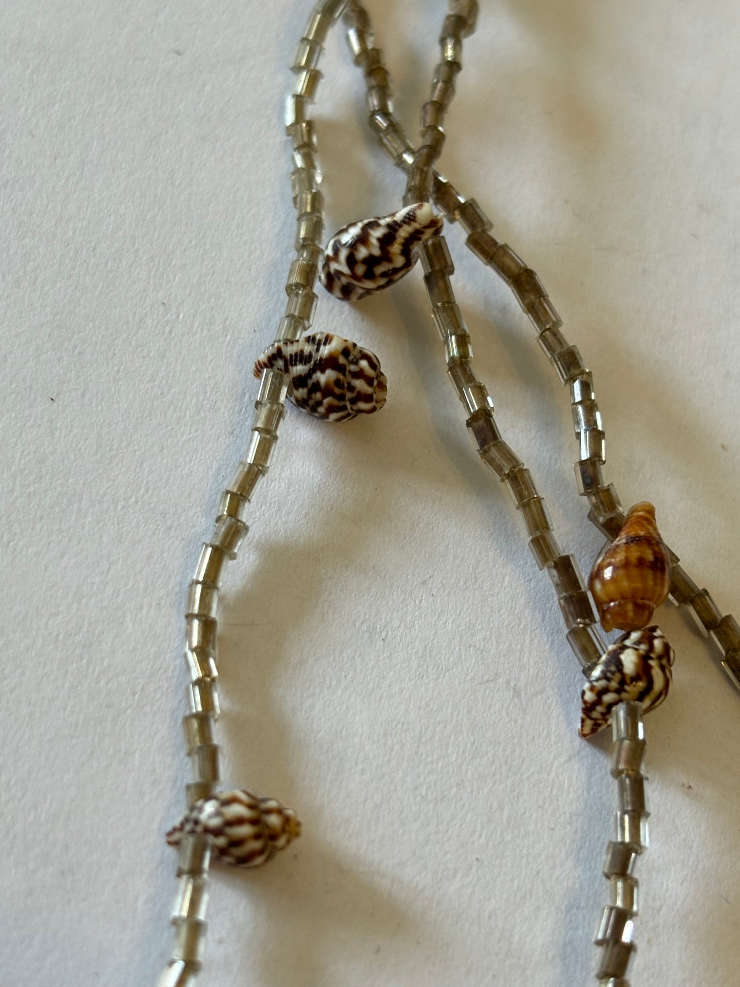 Small smokey triple tier bead necklace with very small seashells spaced along