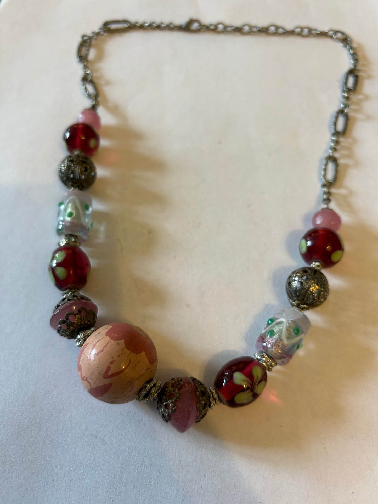 Silver metal chain necklace with decorative pink, silver and red beads