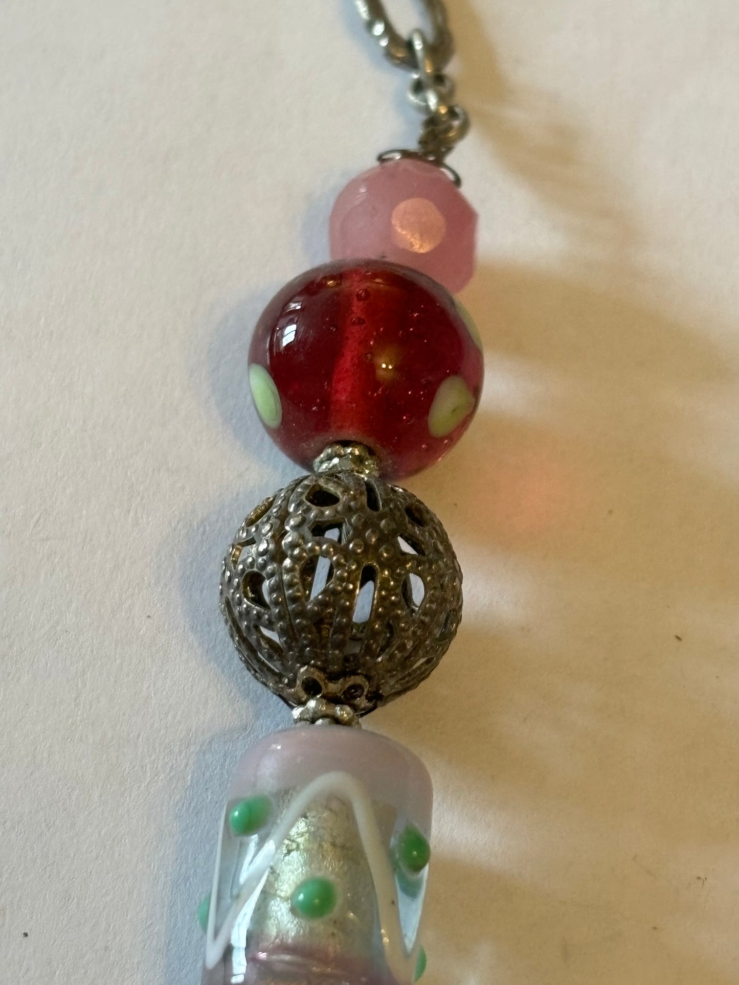 Silver metal chain necklace with decorative pink, silver and red beads