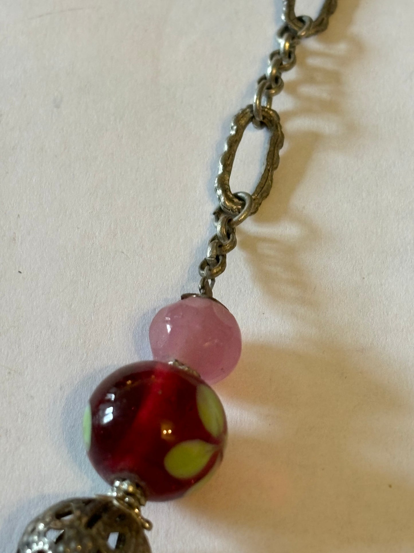 Silver metal chain necklace with decorative pink, silver and red beads