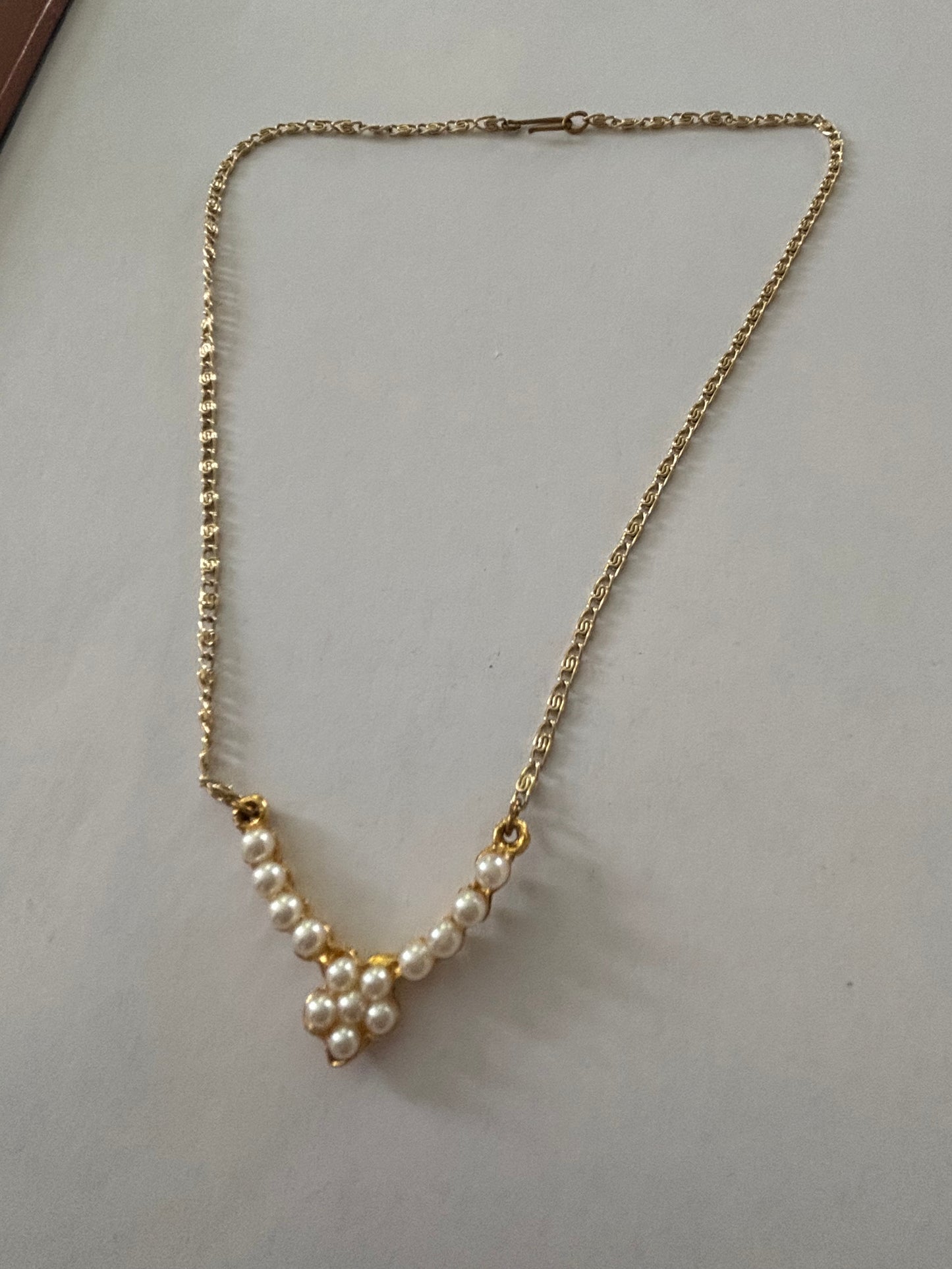 Gold metal chain necklace with V bar pendant of pearlescent beads