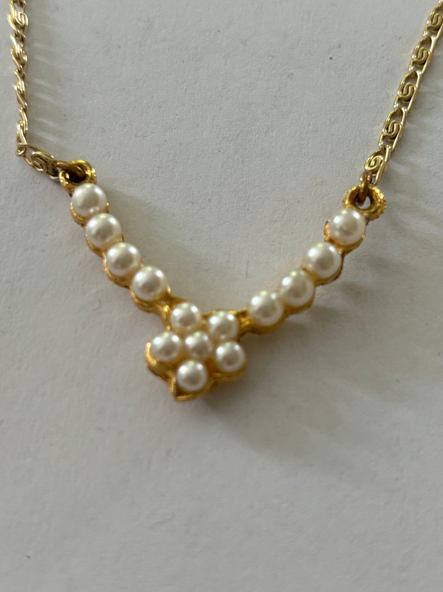 Gold metal chain necklace with V bar pendant of pearlescent beads