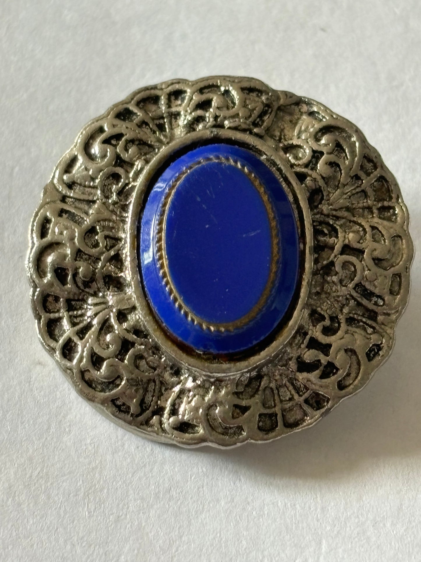 Round silver metal ornate scarf clip with oval blue centre