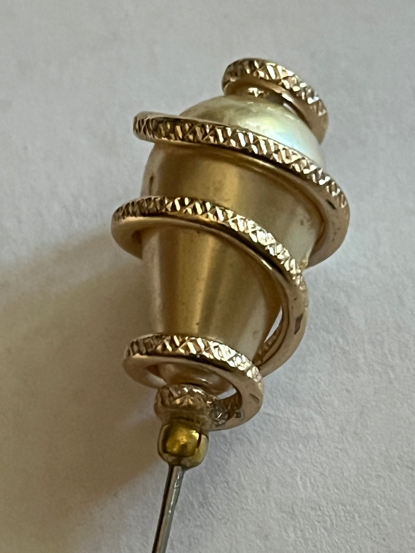 Peardrop shaped pearlescent bead hat pin wrapped in a spiral textured gold wrap