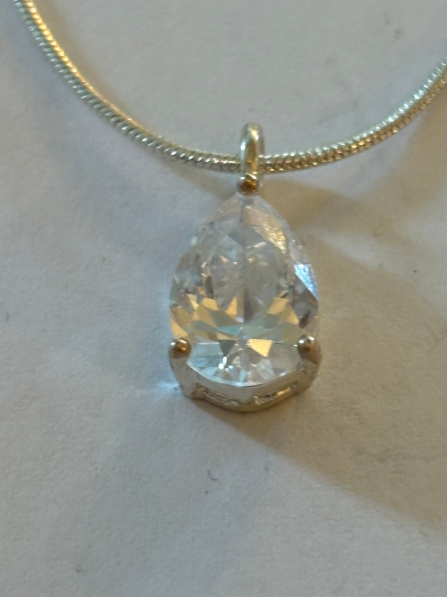 Bright silver smooth rope necklace with teardrop white stone pendant