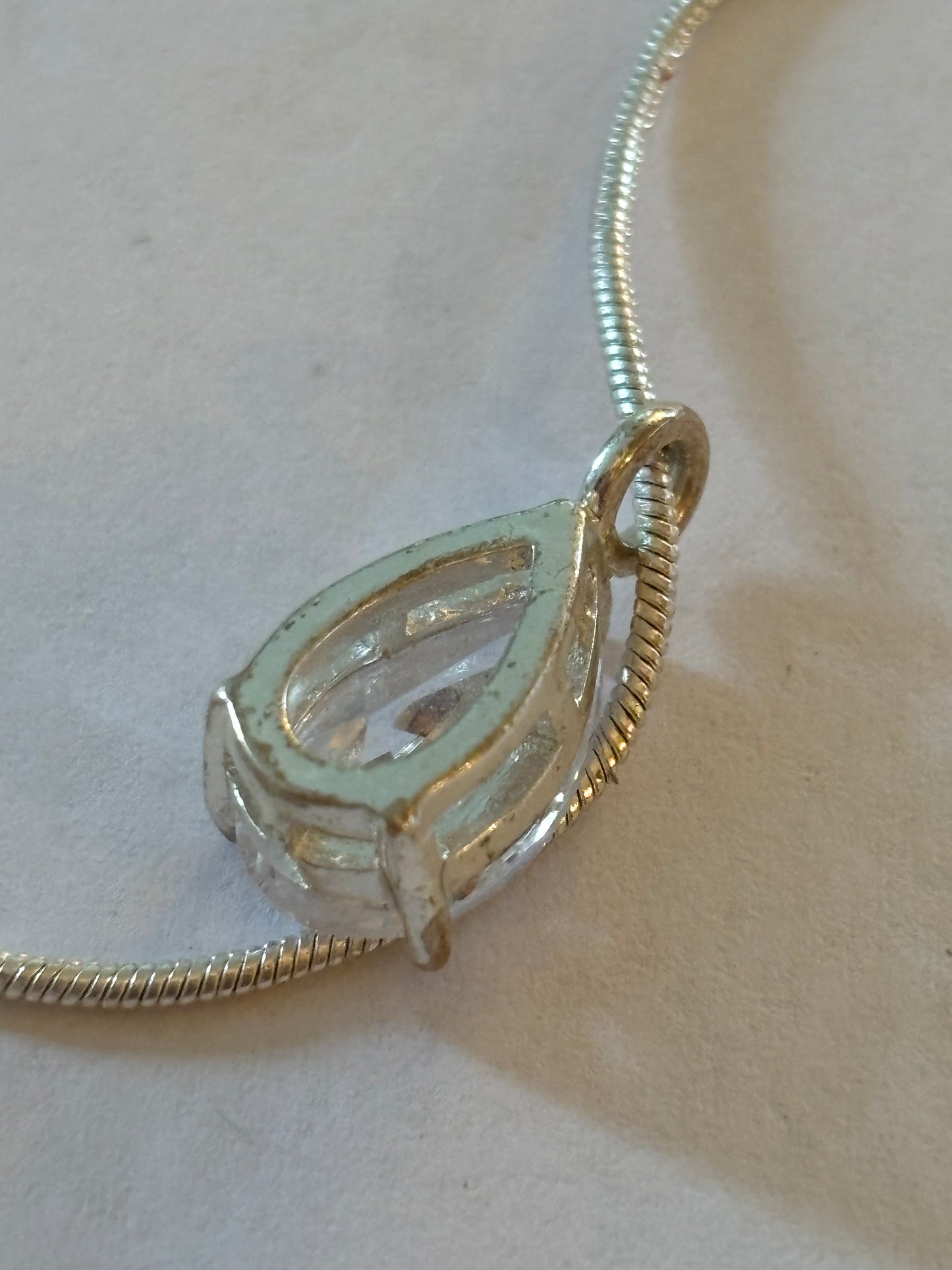 Bright silver smooth rope necklace with teardrop white stone pendant