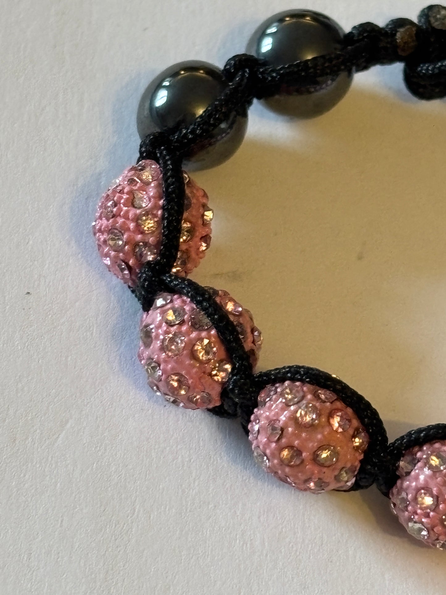 Black friendship bracelet with graphite and sparkly pink beads