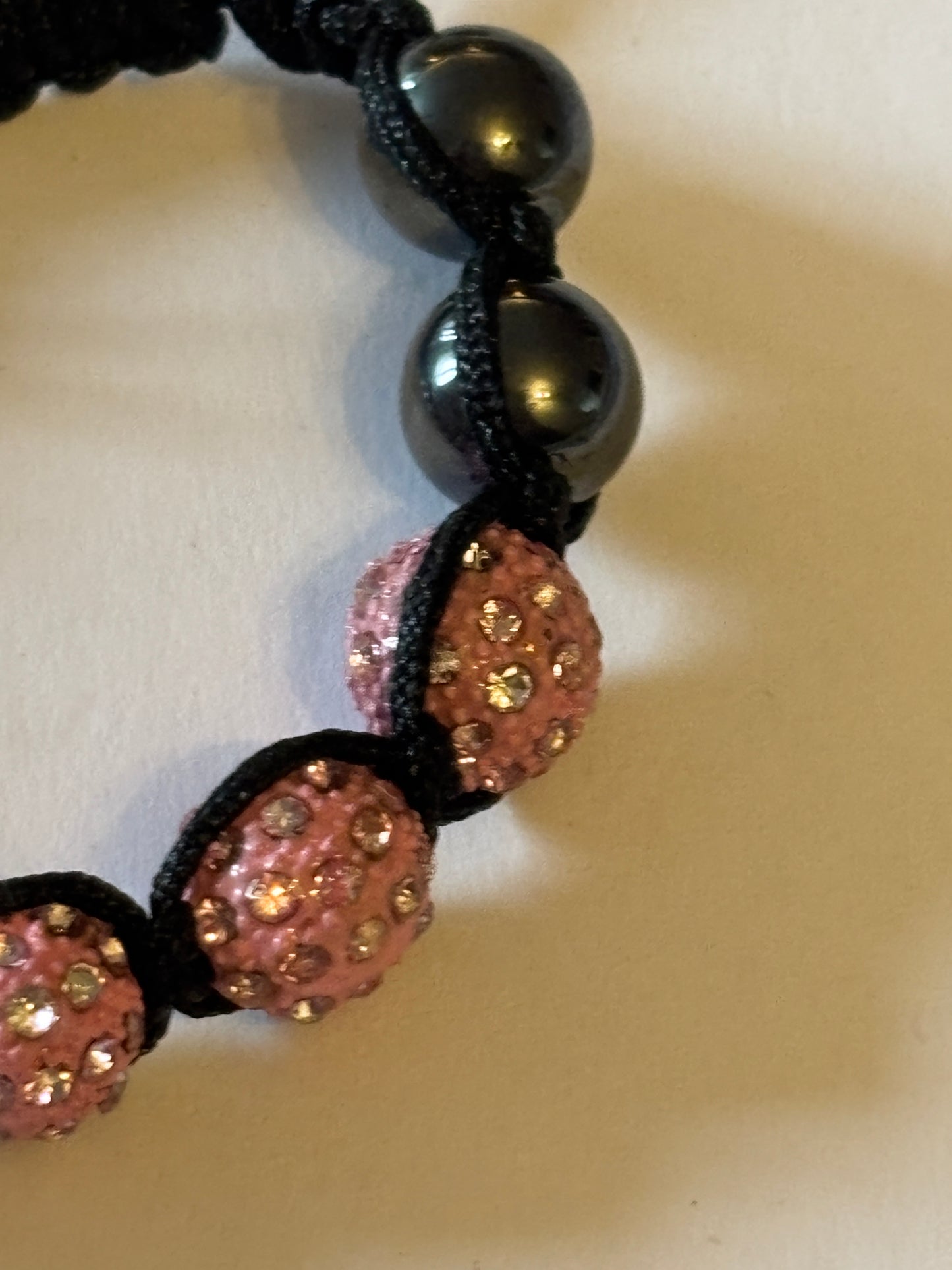 Black friendship bracelet with graphite and sparkly pink beads