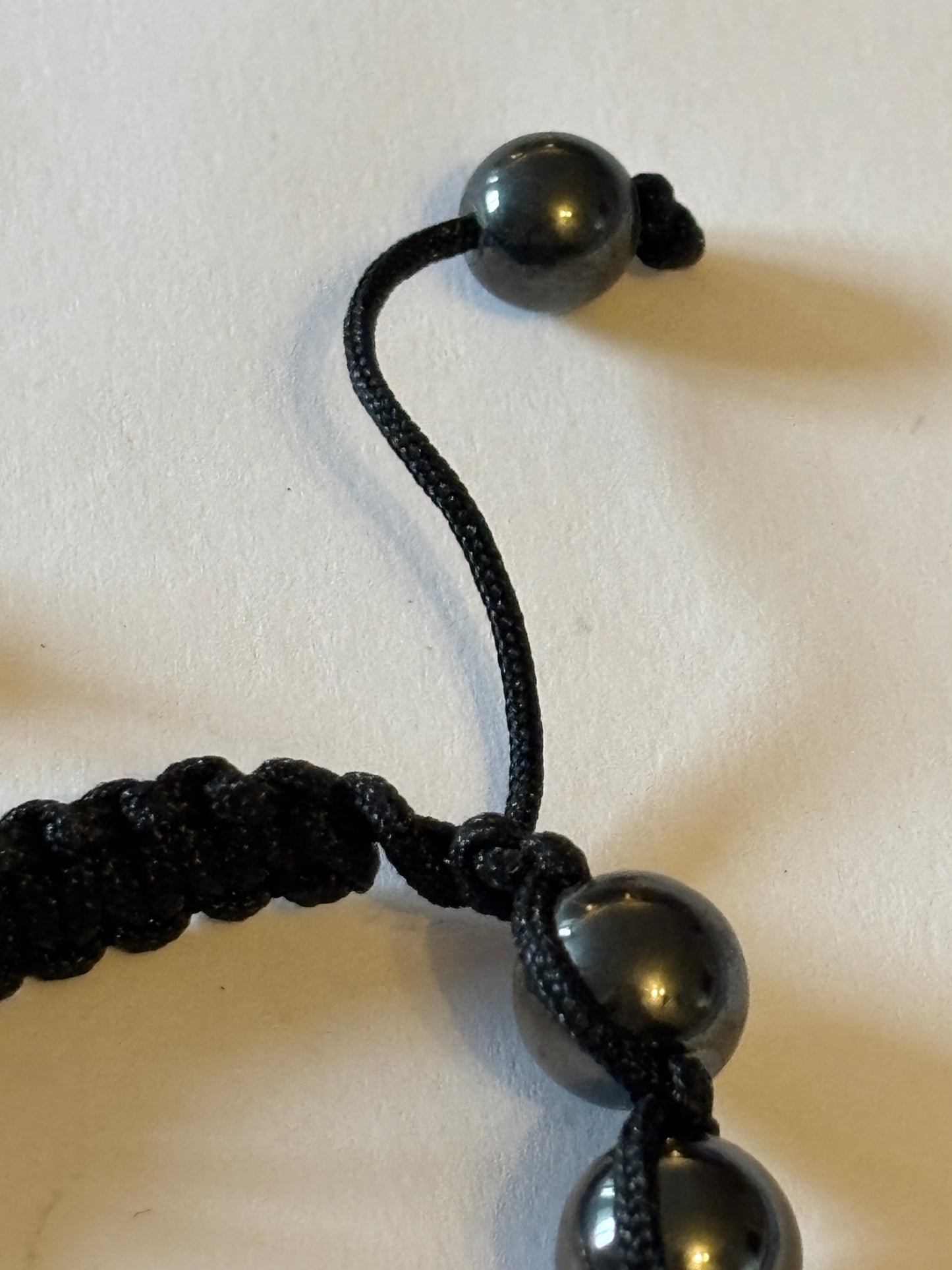 Black friendship bracelet with graphite and sparkly pink beads