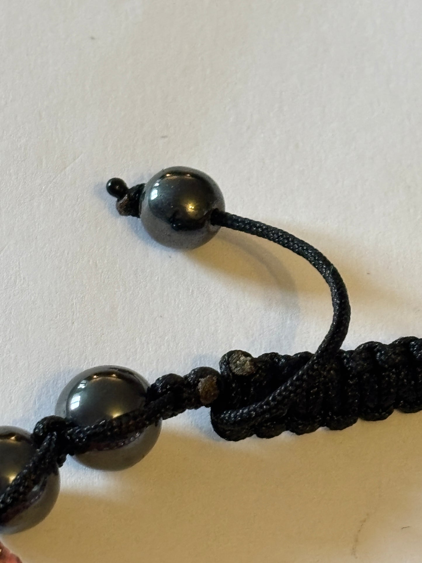 Black friendship bracelet with graphite and sparkly pink beads