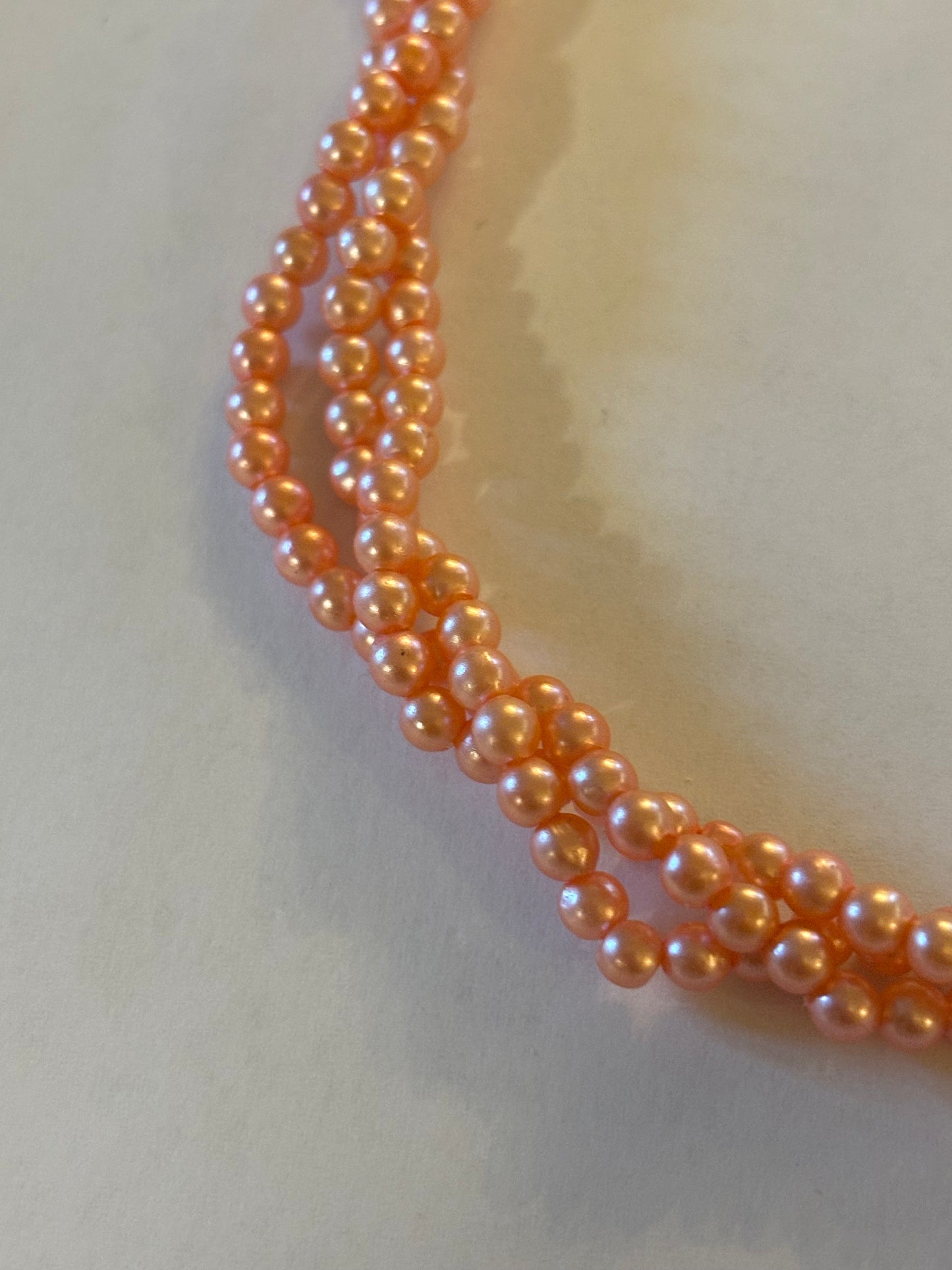 Triple strand bright pearlescent small pink bead necklace