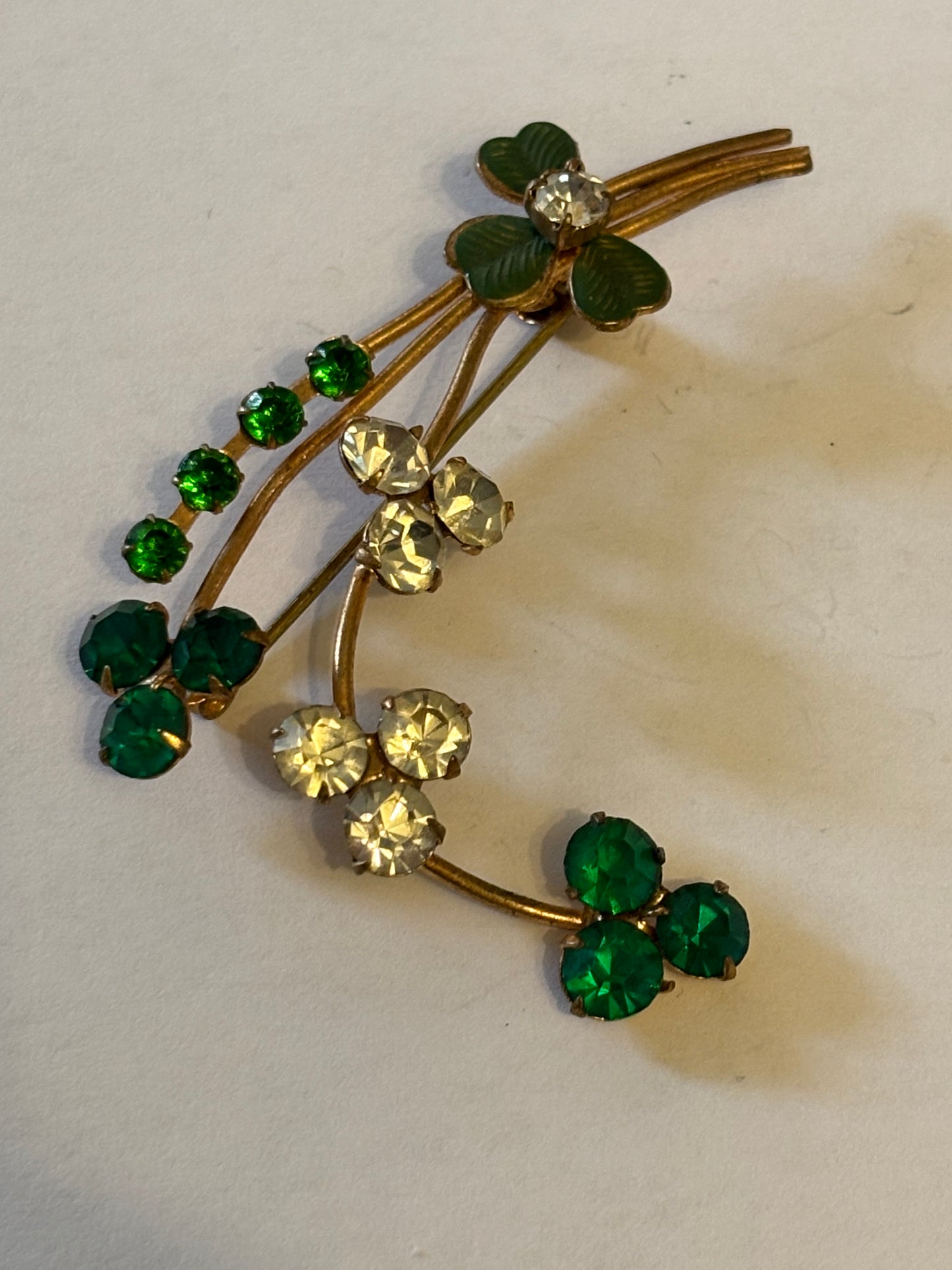 Gold flower spray brooch with vivid green and white stones